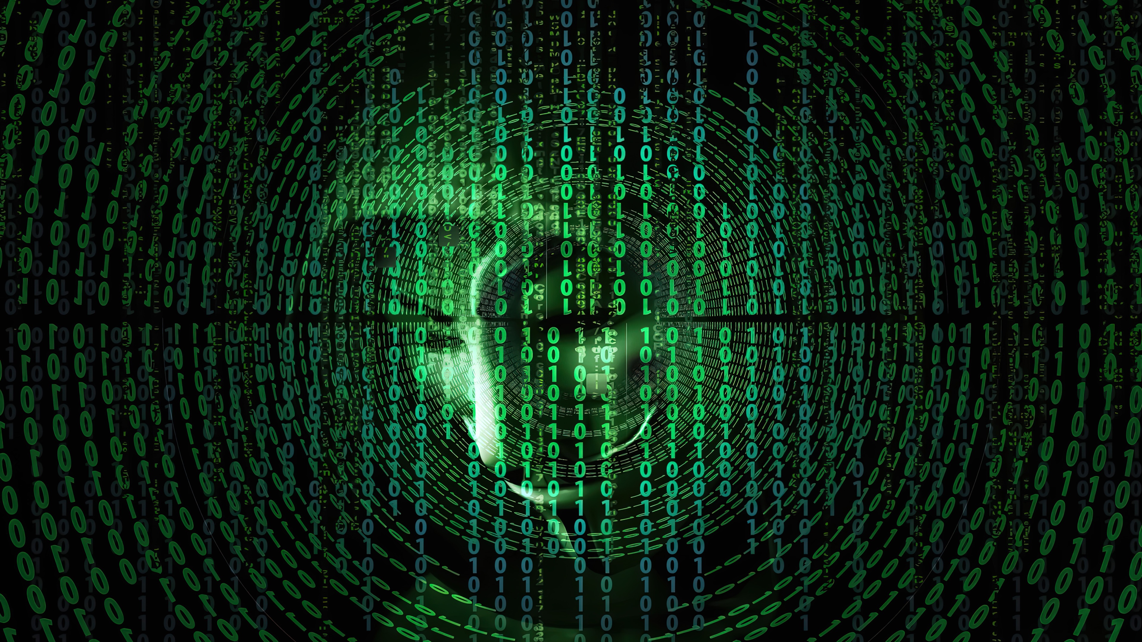 A man in a dark hoodie surrounded by glowing green binary code and digital data streams.