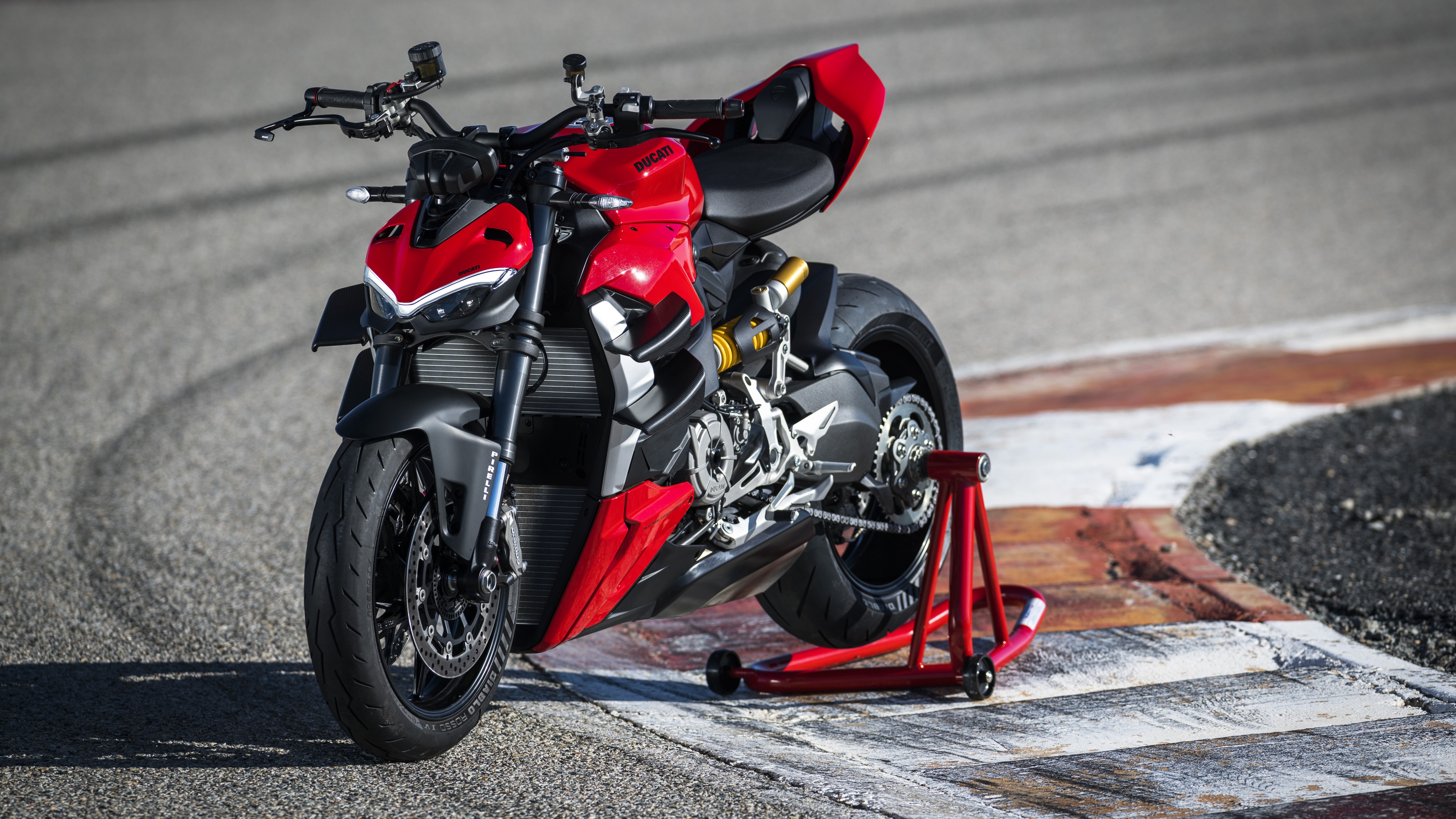 A red Ducati Streetfighter V2 motorcycle speeding through a corner on a professional race track