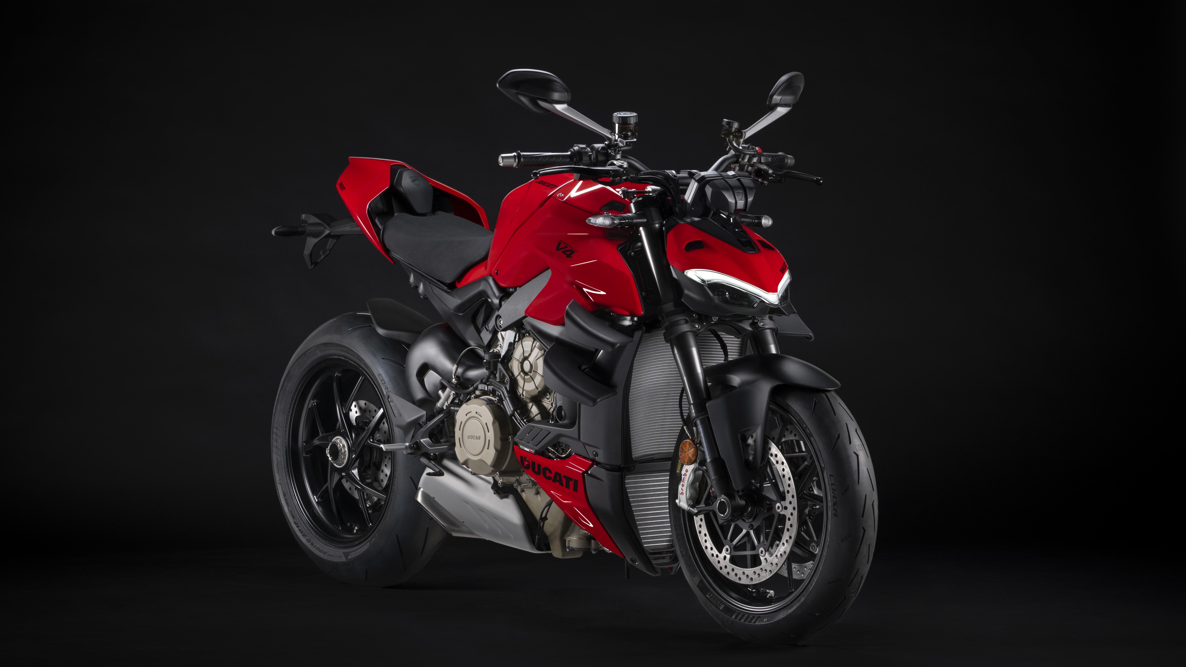 A high-detail shot of a 2023 Ducati Streetfighter V4 S motorcycle against a dark, moody background.