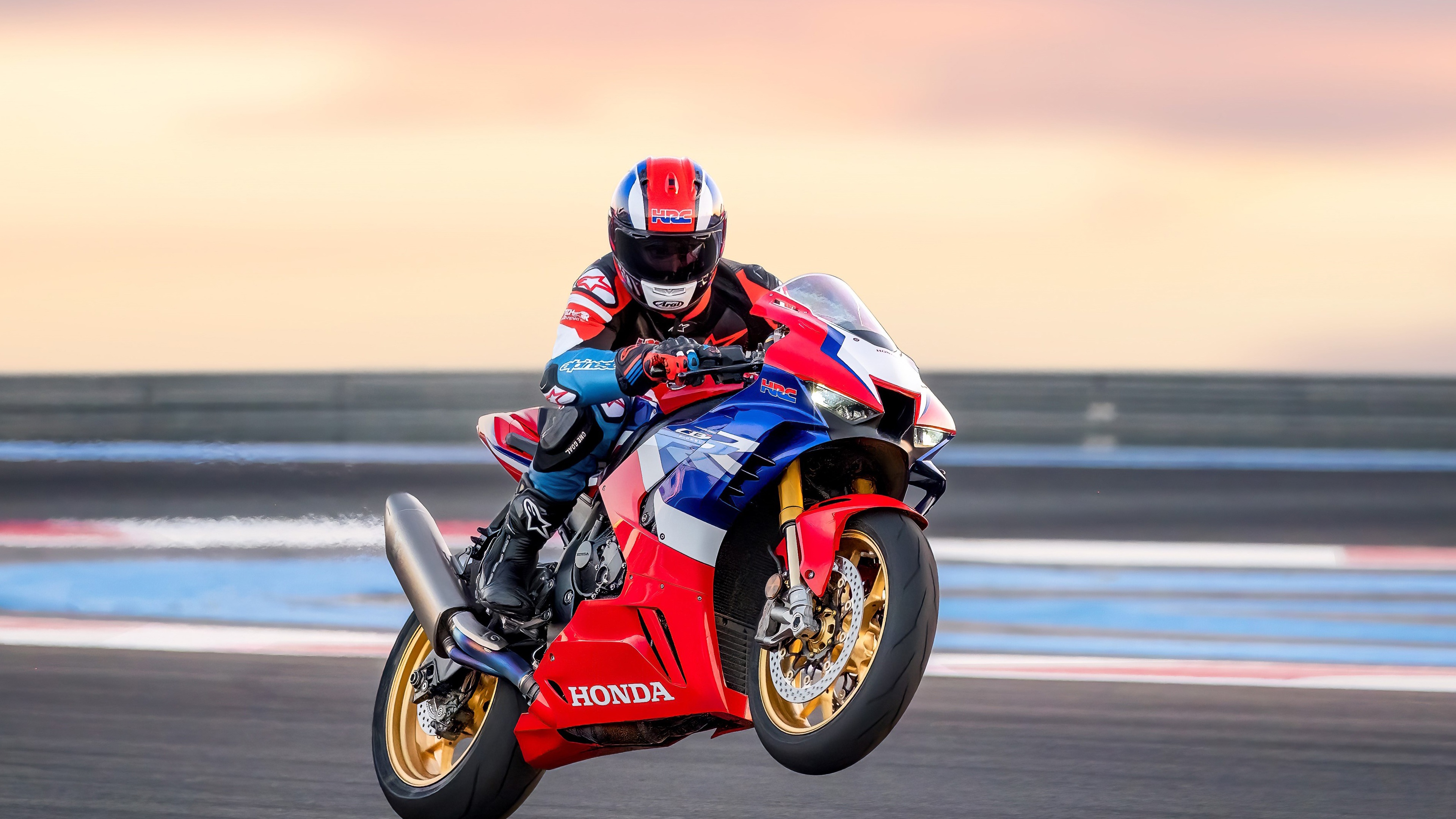 A 2022 Honda CBR1000RR-R Fireblade SP motorcycle performing a high-speed maneuver on a professional racing circuit.