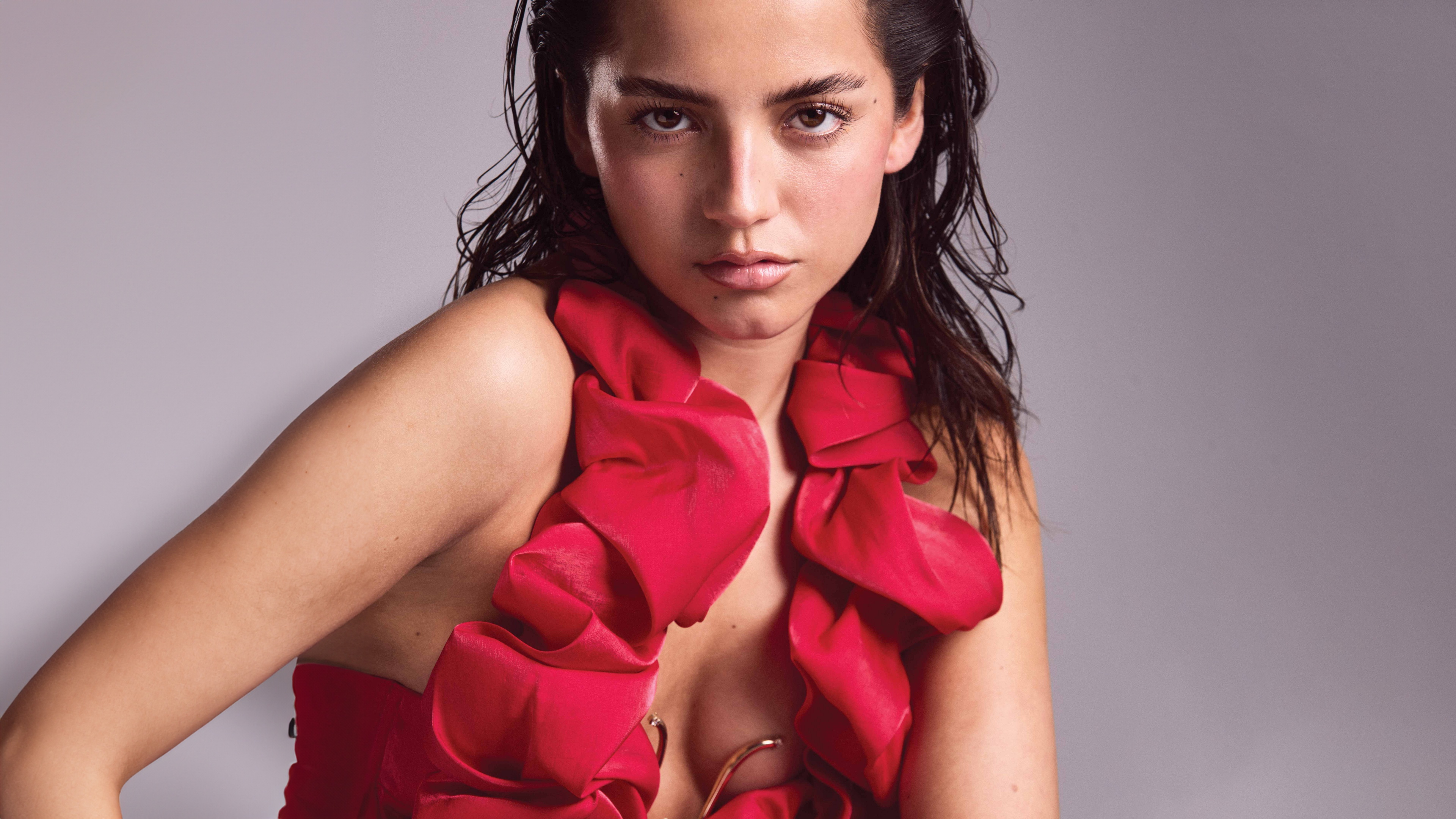 A high-resolution close-up portrait of actress Isabela Merced wearing an elegant red dress.
