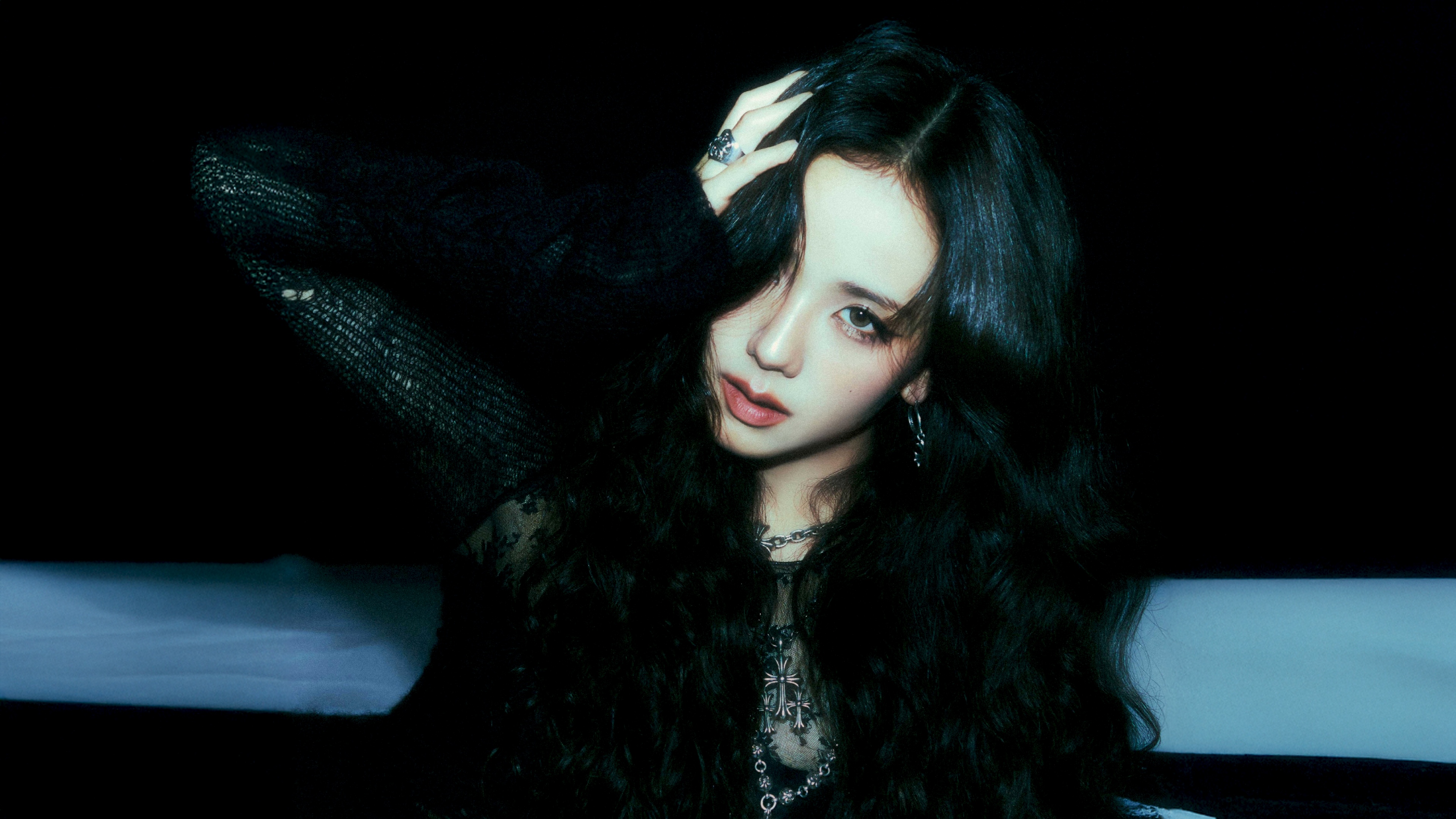 Close-up portrait of Jisoo from BLACKPINK against a dark, atmospheric background.