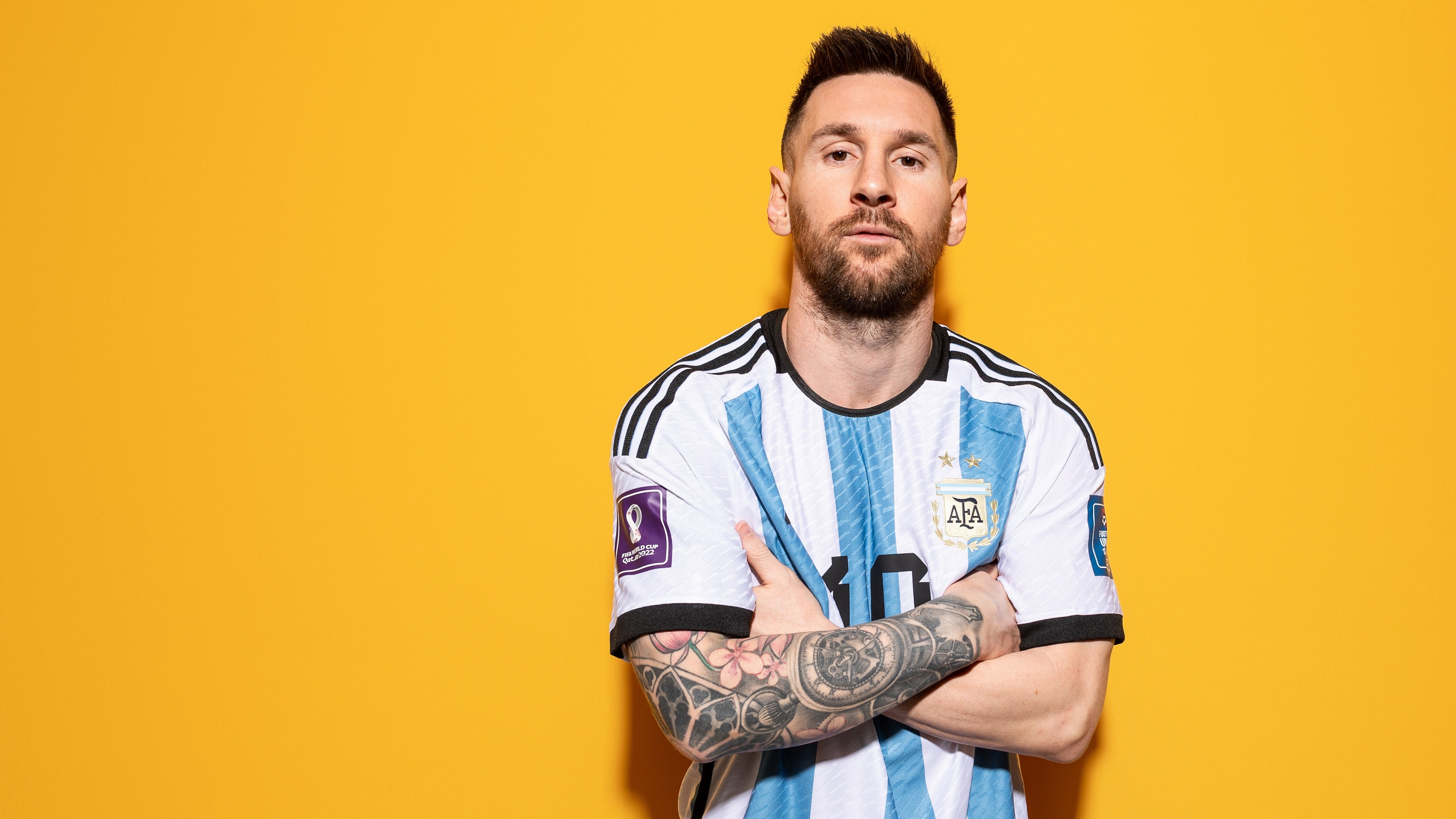 Close-up portrait of soccer player Lionel Messi against a bright yellow background.