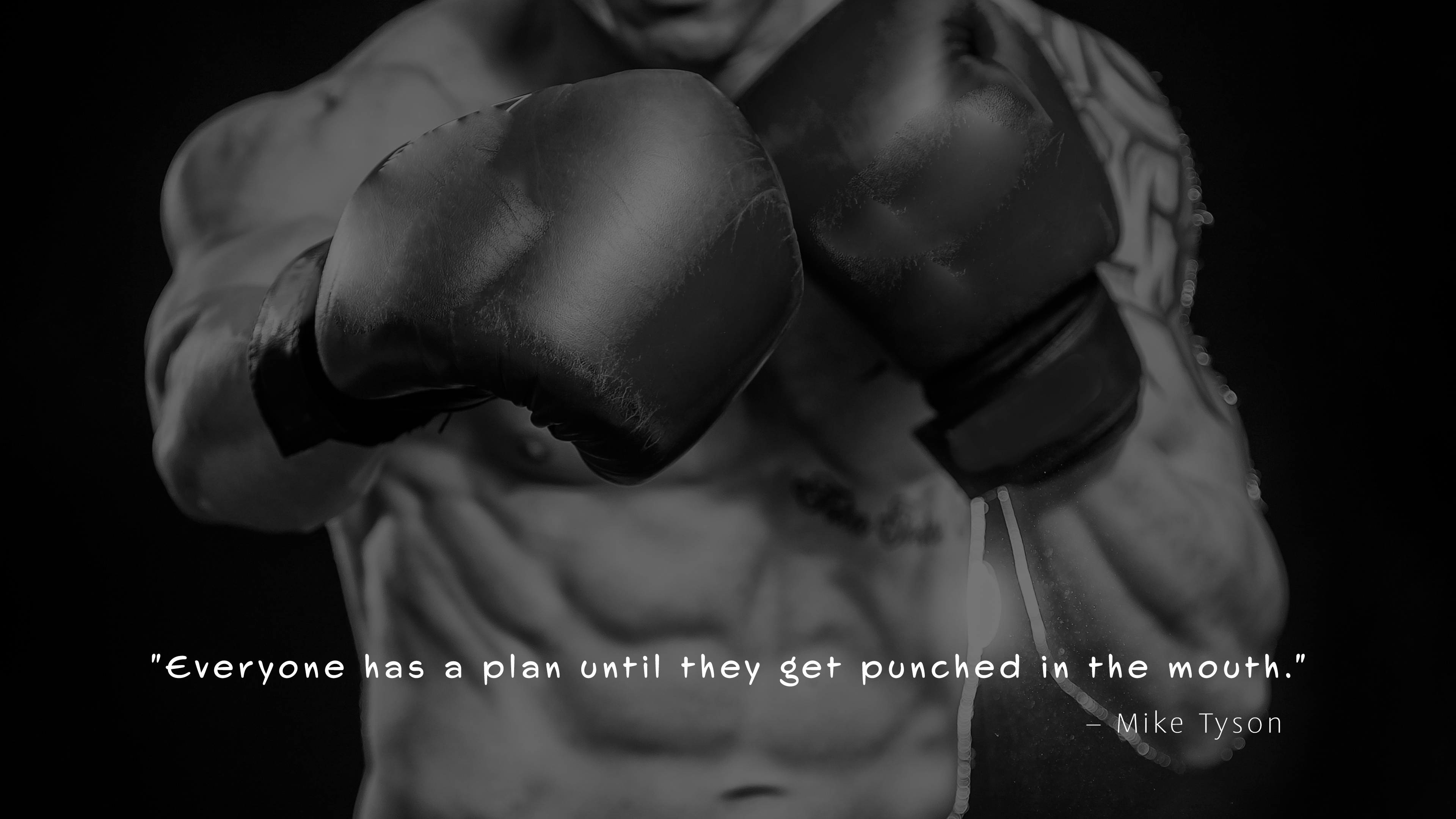 A monochrome, high-contrast image of Mike Tyson performing a powerful punch against a dark, minimalist background.