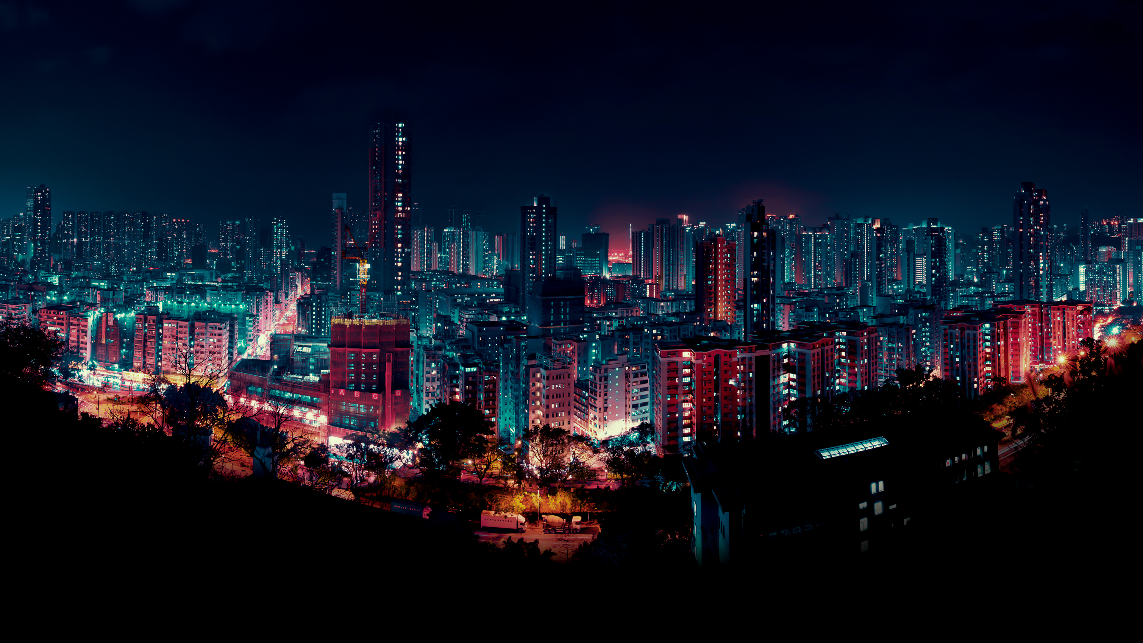 A sprawling night cityscape with bright lights from skyscrapers under a dark sky.