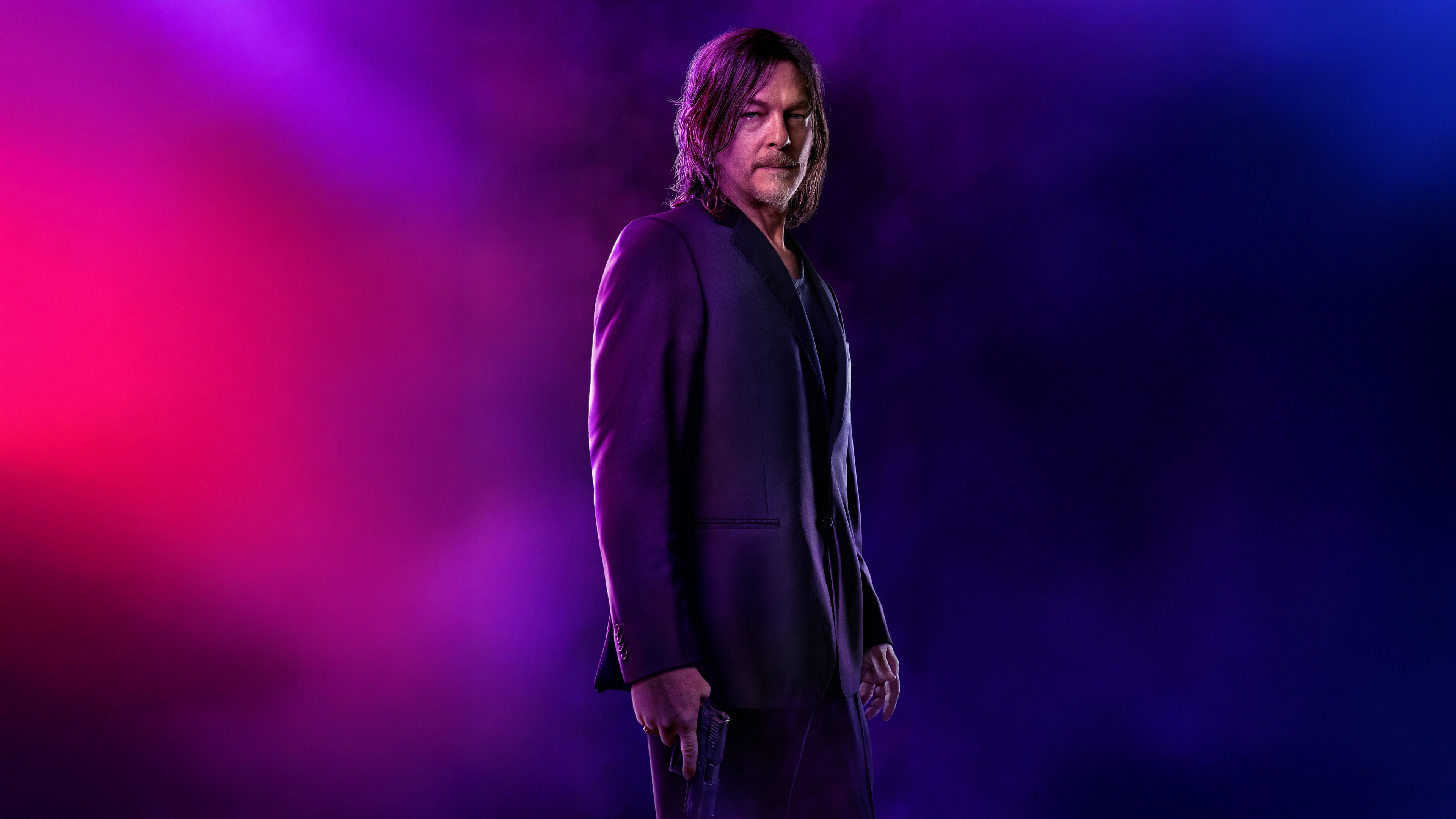 A high-resolution cinematic shot of Norman Reedus in a ballerina pose set against a glowing neon background.