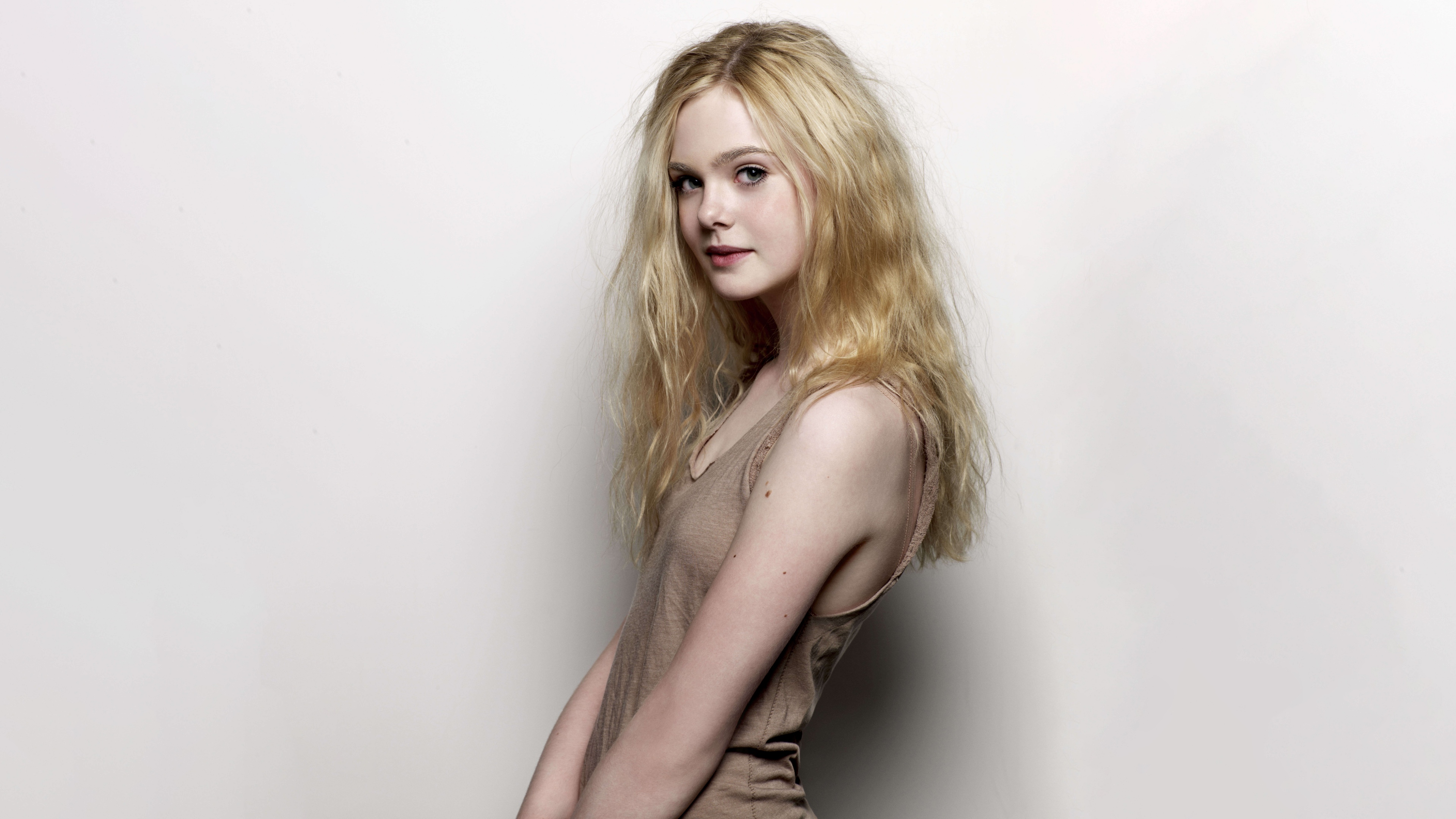 A high-resolution close-up portrait of blonde actress Elle Fanning set against a plain white background.