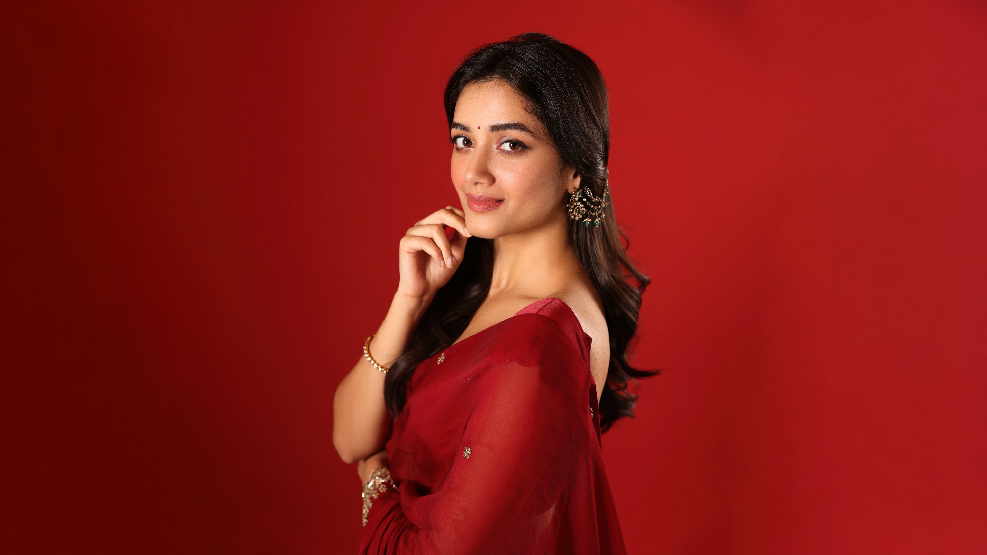 Bhagyashri Borse wearing a traditional saree against a red background