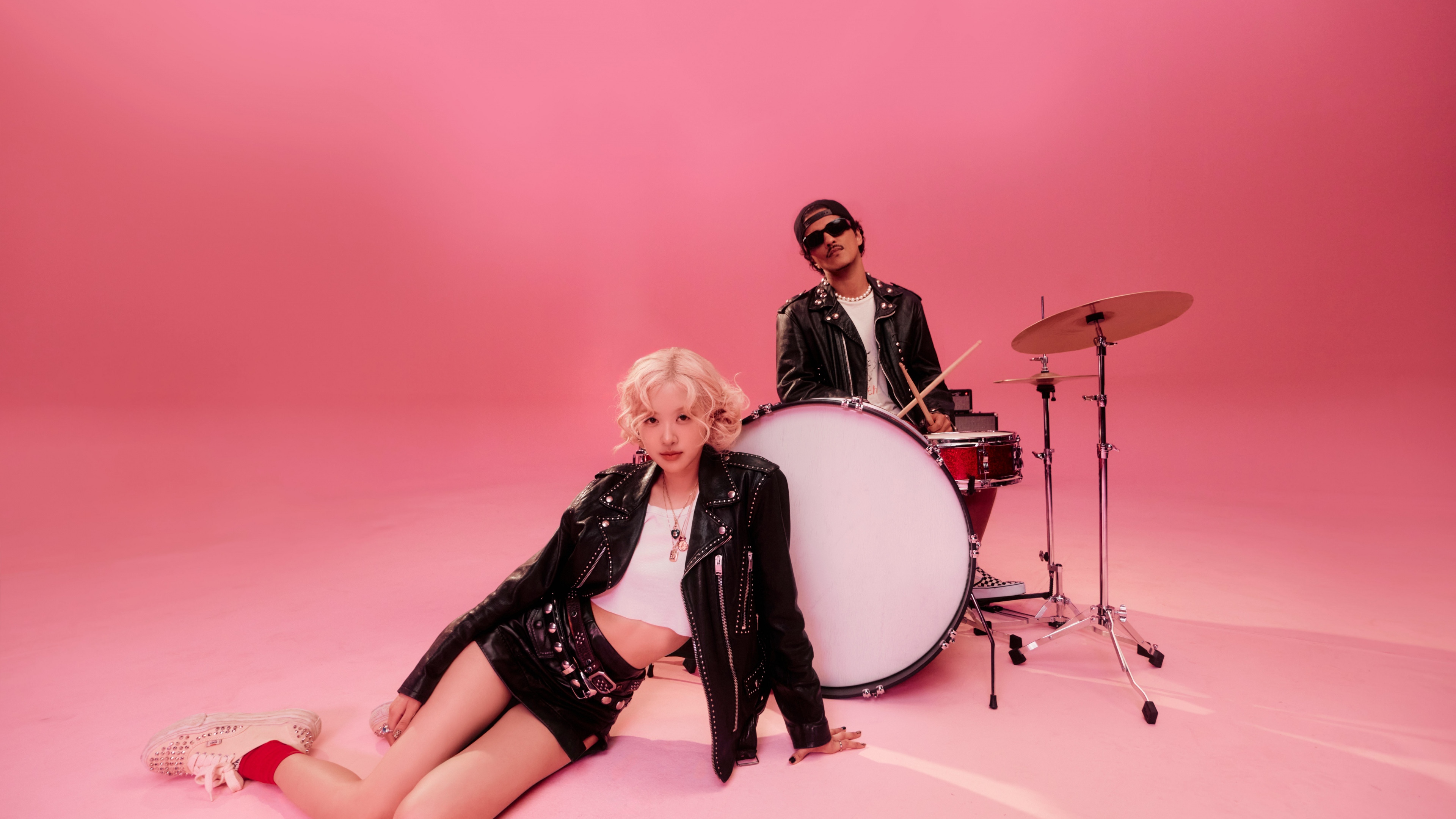 A high-resolution close-up of Rosé from Blackpink and Bruno Mars against a solid red background.