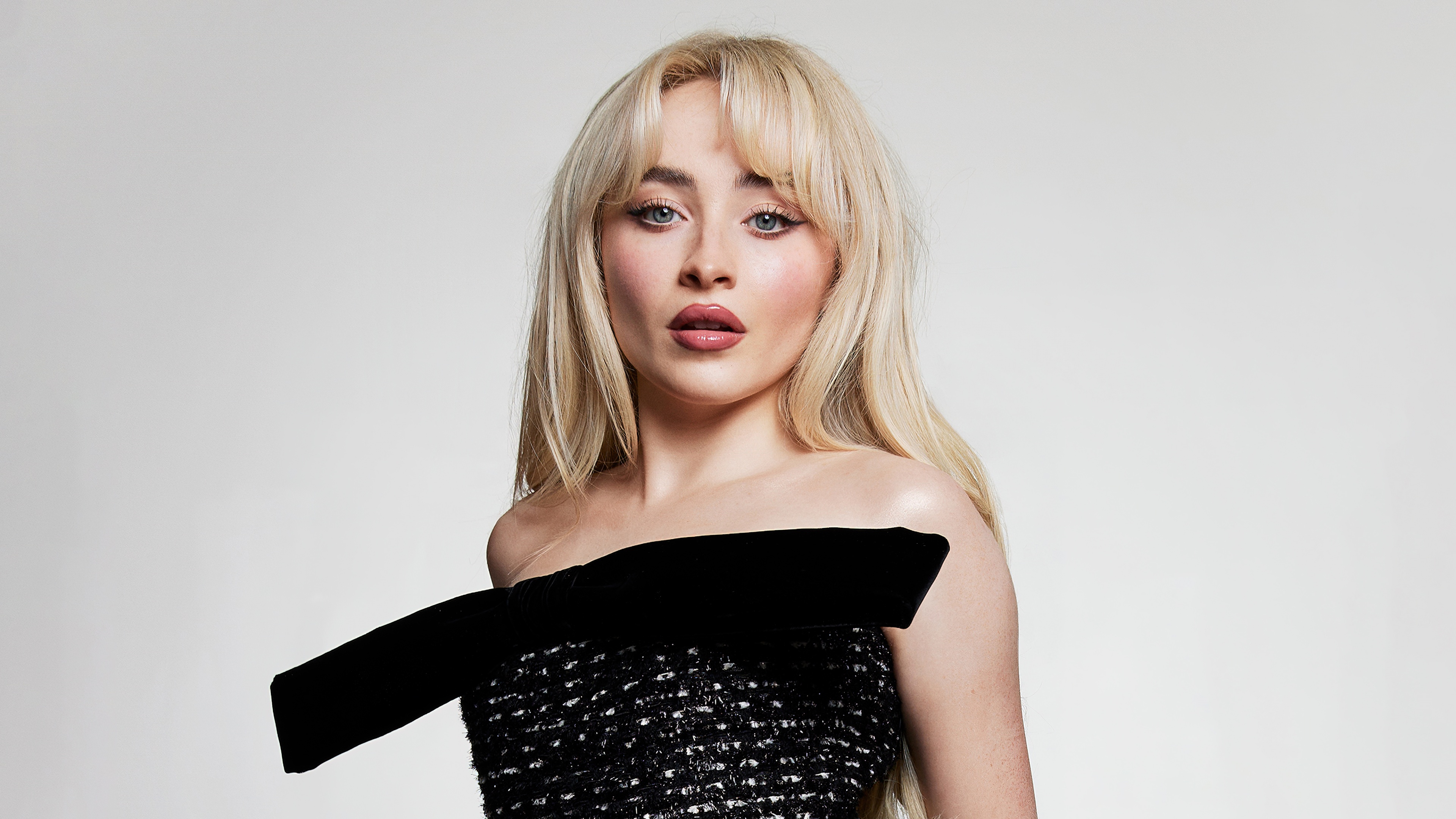 A professional studio portrait of American singer Sabrina Carpenter set against a plain white background.
