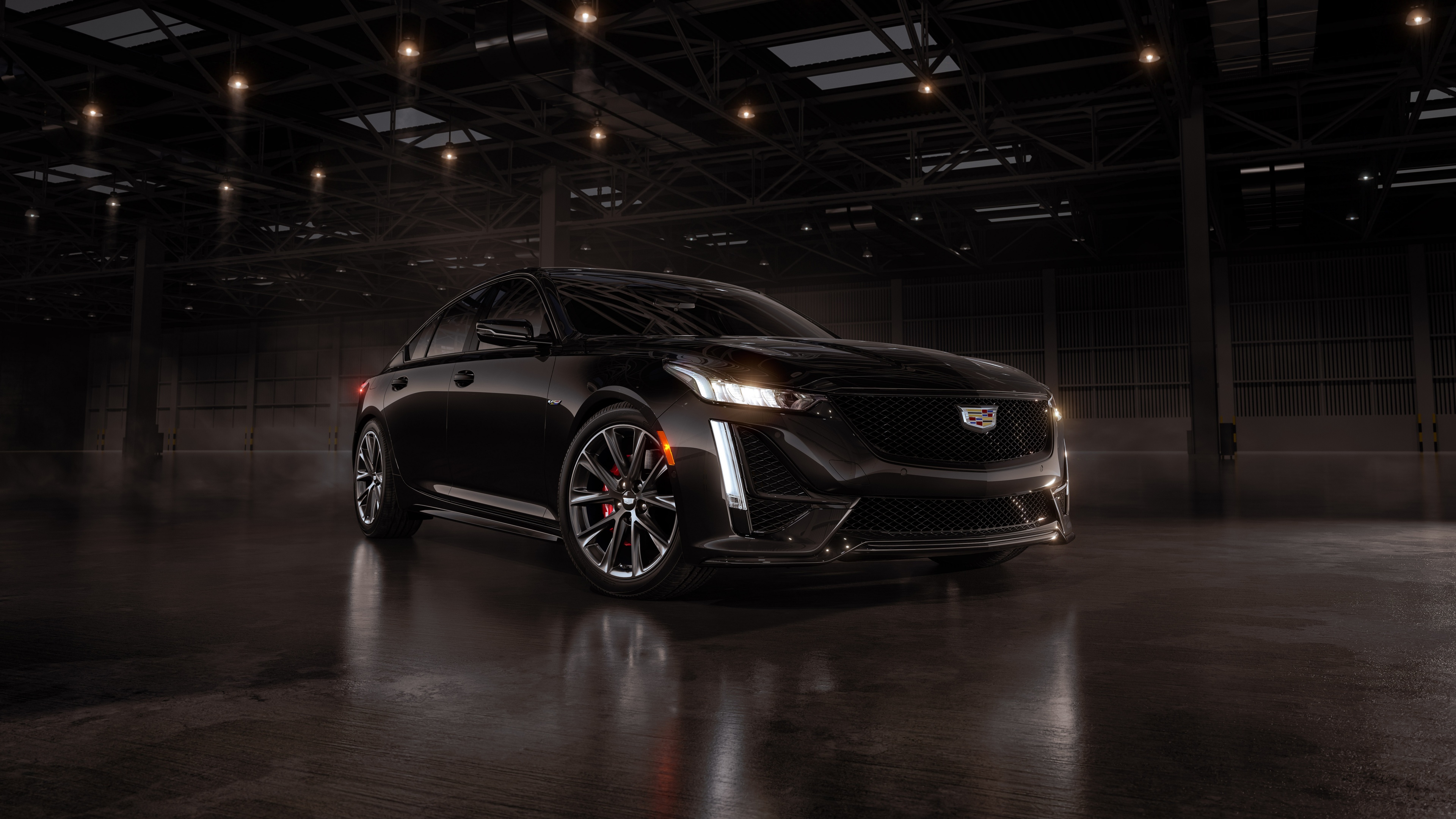 A Cadillac CT5-V Blackwing sedan featured in a dark, moody, and cinematic setting with deep shadows and high-contrast lighting.