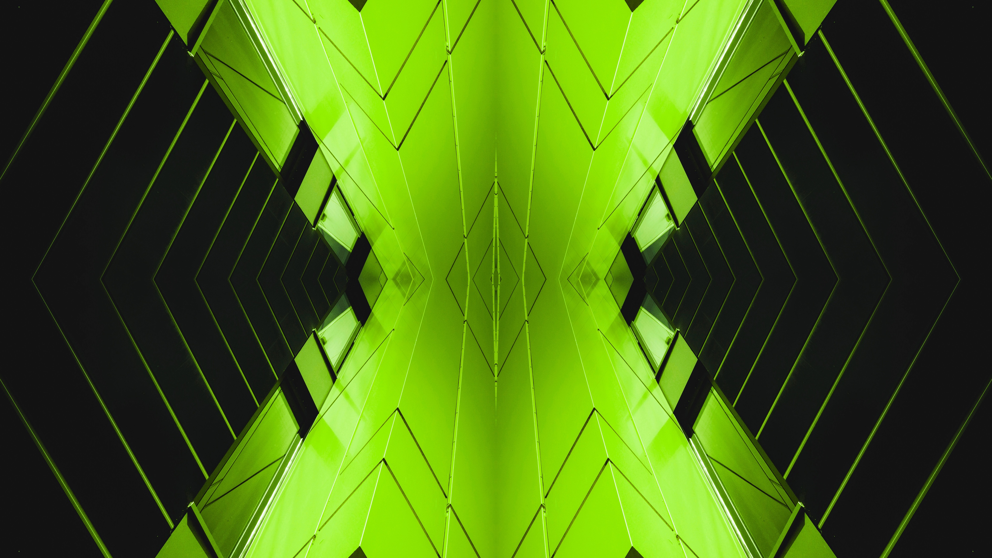 Symmetrical modern architectural structure with geometric patterns and a green background in Budapest, Hungary.