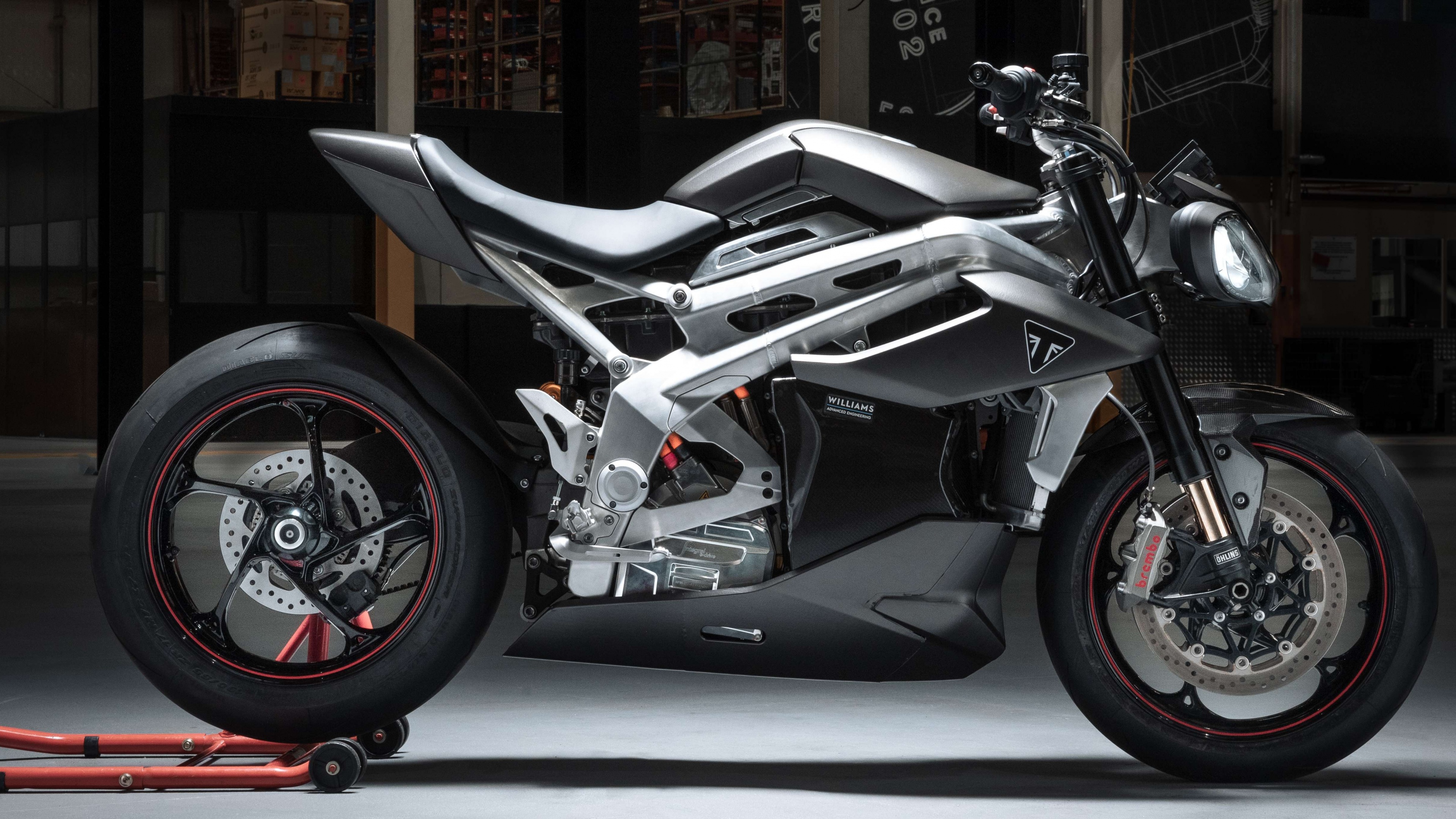A detailed close-up of the Triumph TE-1 electric sports motorcycle featuring a sleek, modern design and metallic finish.