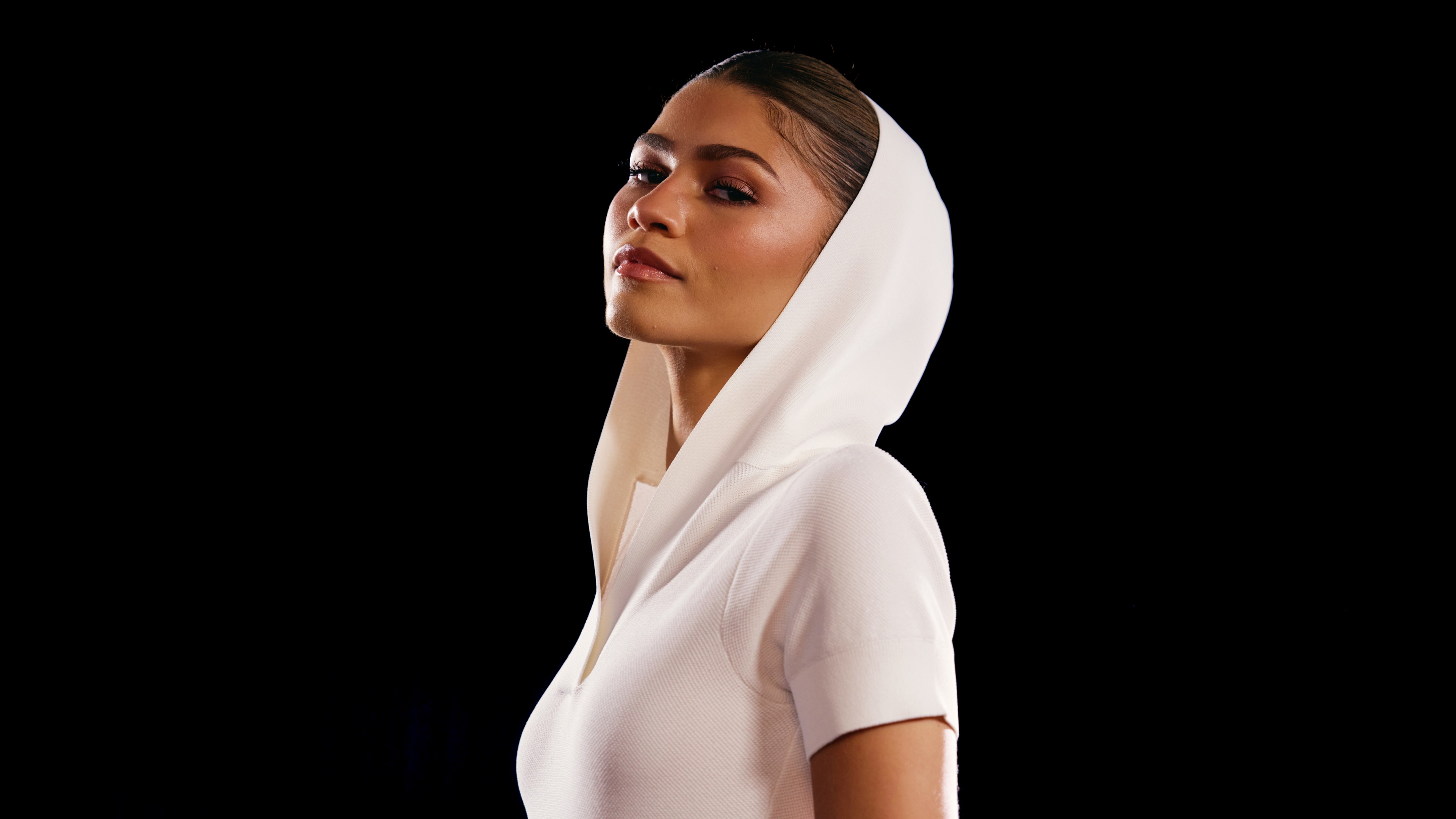 A high-resolution, high-contrast close-up portrait of Zendaya against a solid black background.