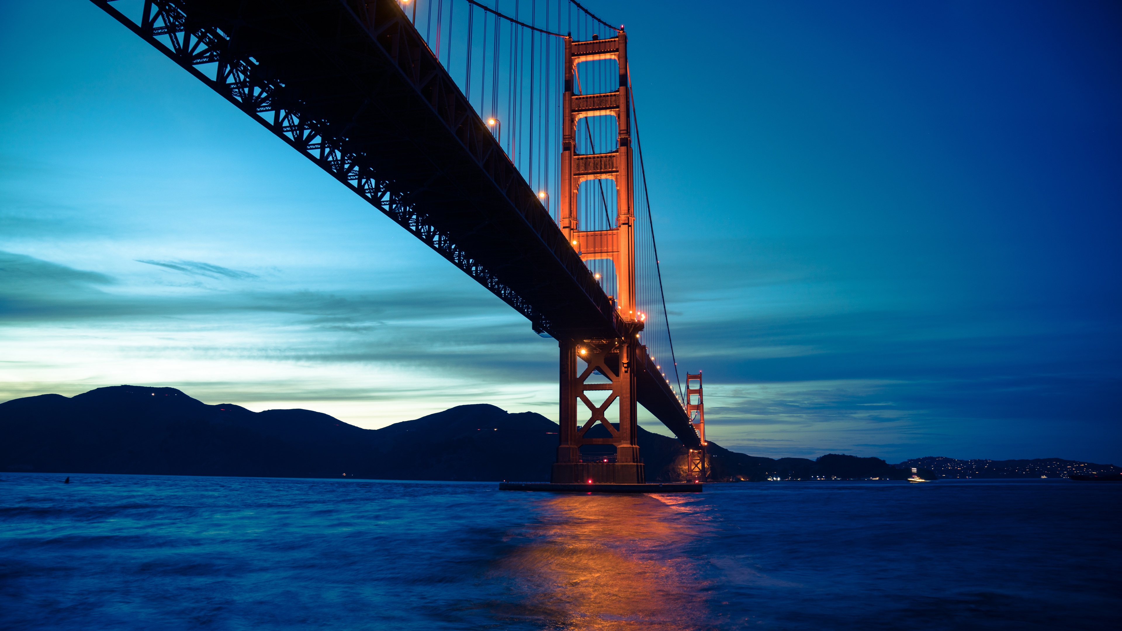 A scenic view of the Golden Gate Bridge in San Francisco under a colorful evening sunset sky.