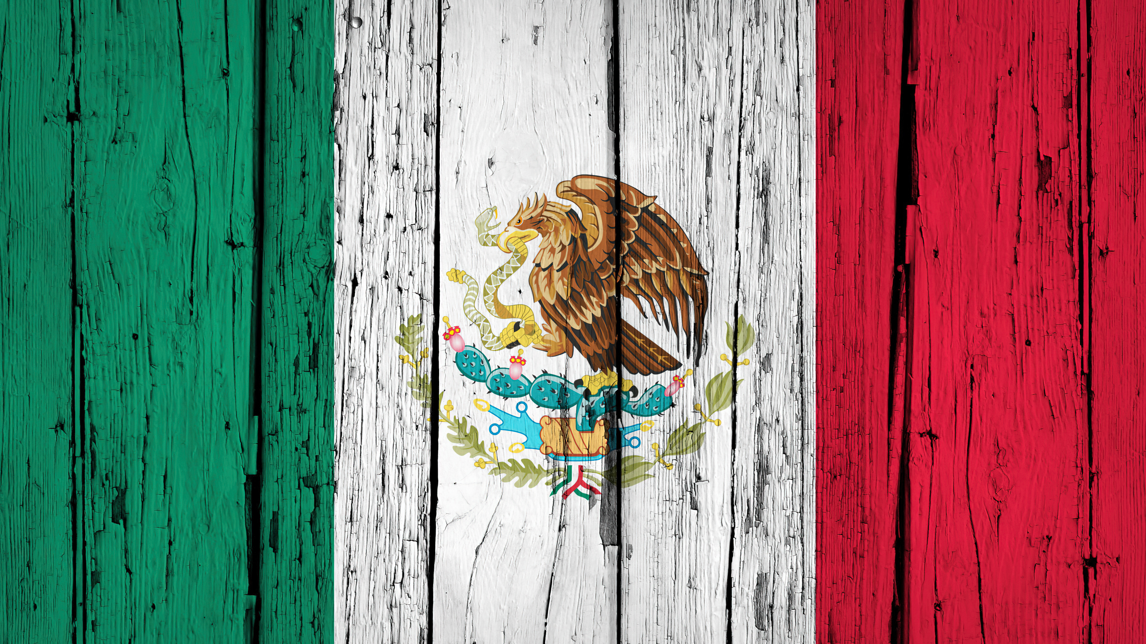 The national flag of Mexico resting on a rustic wooden plank background.