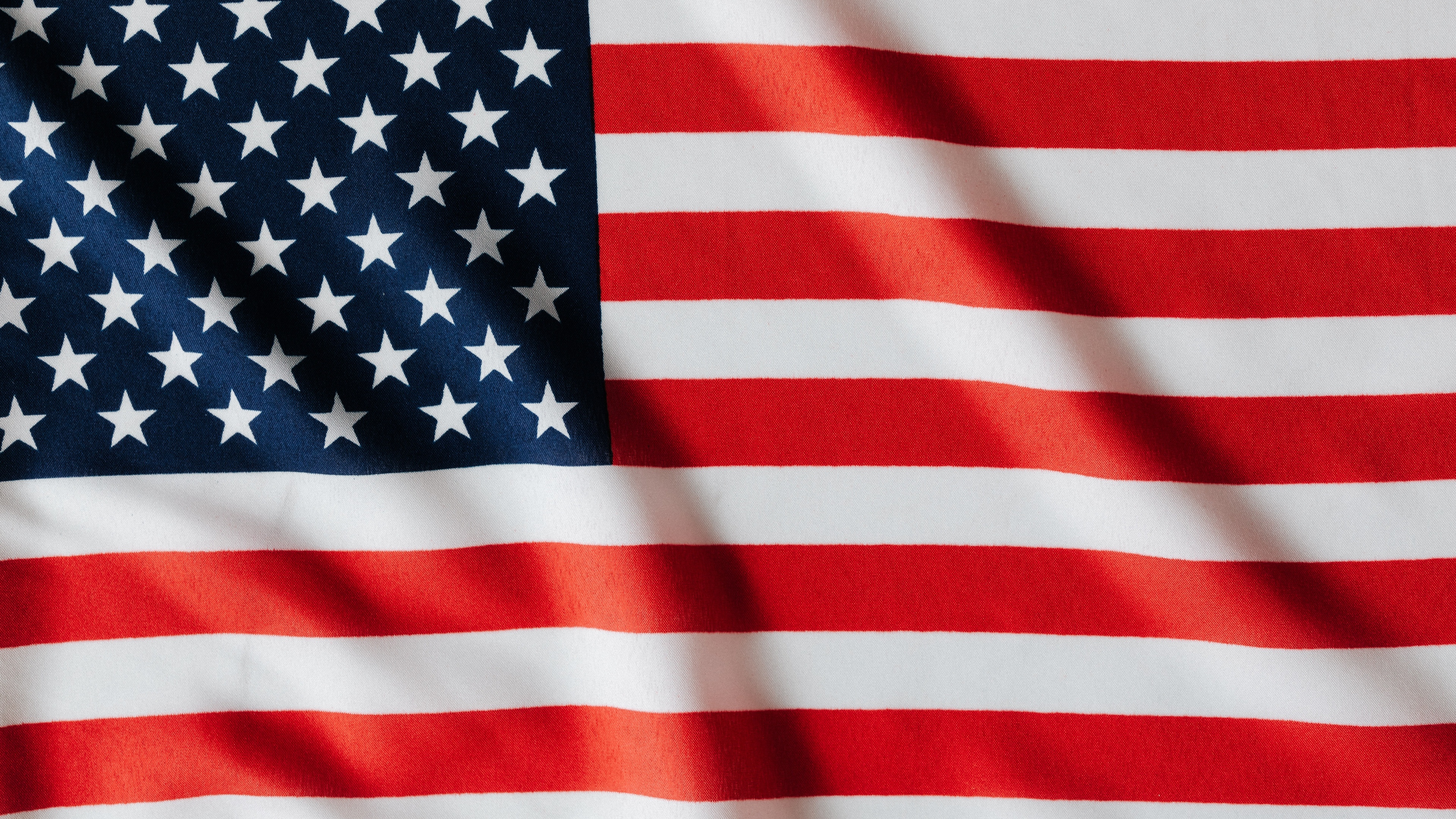 A high-resolution 5K close-up of the United States national flag featuring the stars and stripes.