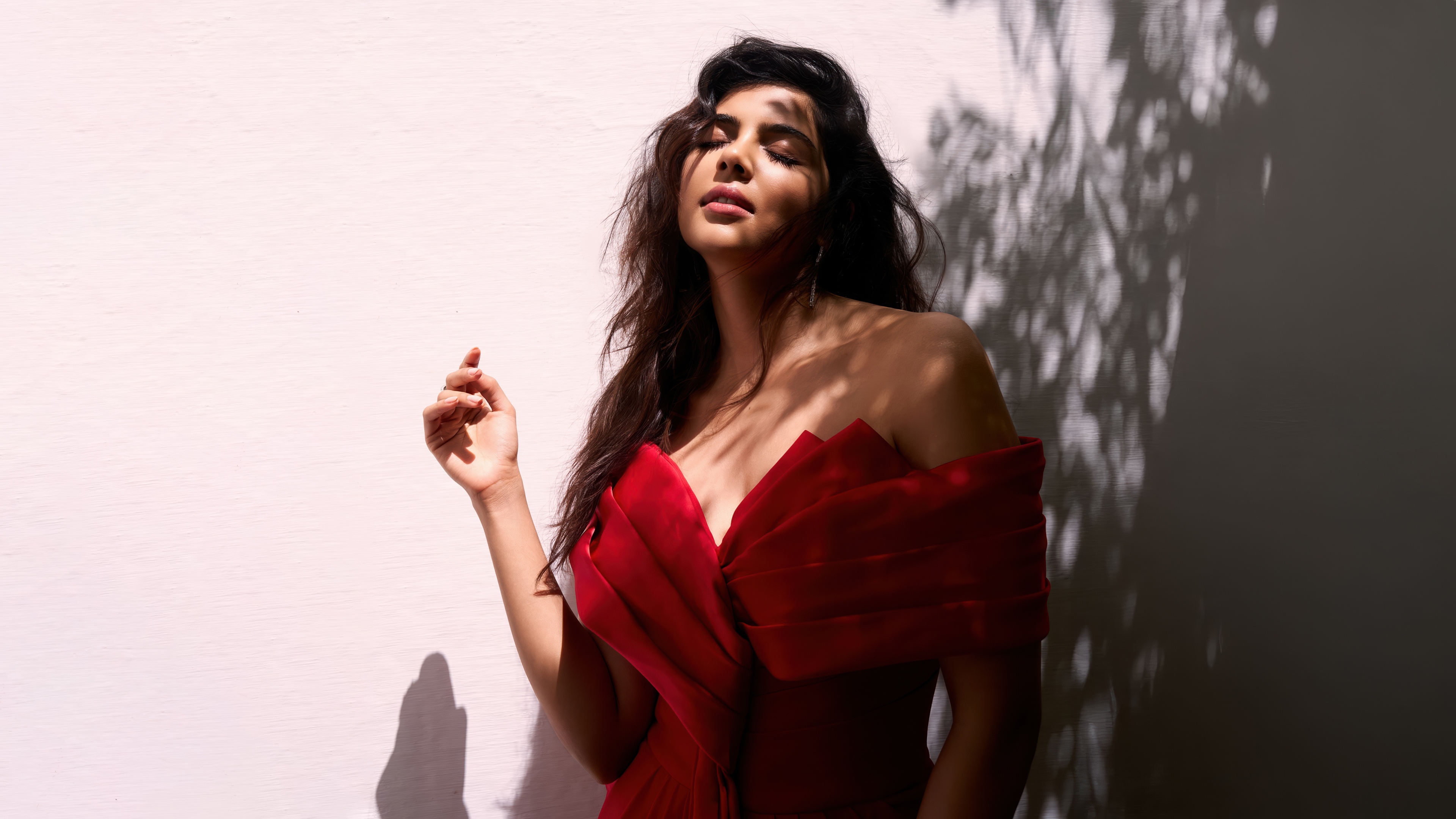 A beautiful portrait of Indian actress Kalyani Priyadarshan wearing an elegant red dress.