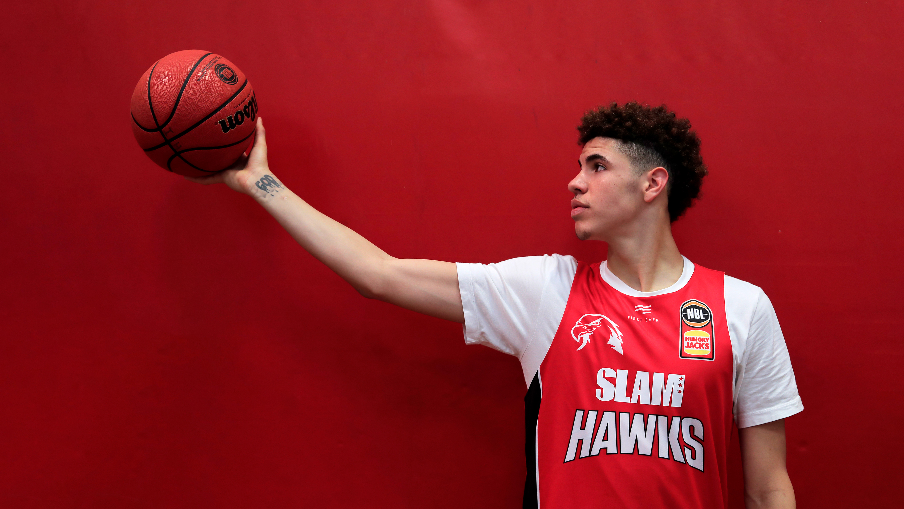 NBA basketball player LaMelo Ball featured against a bold red background