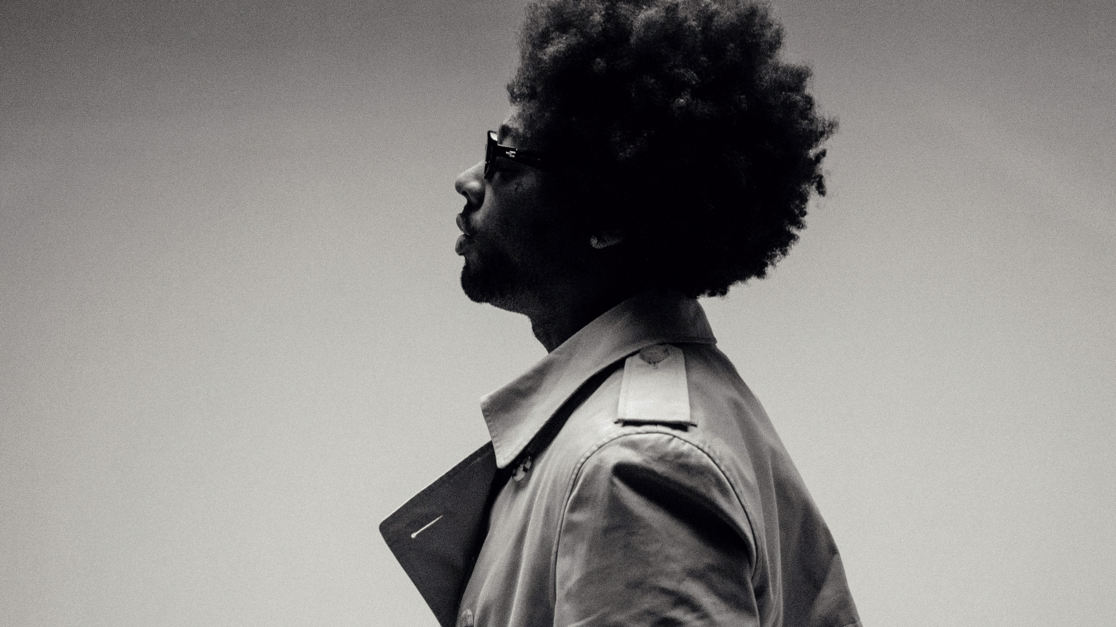 A high-detail, monochrome portrait of American R&B singer Brent Faiyaz.