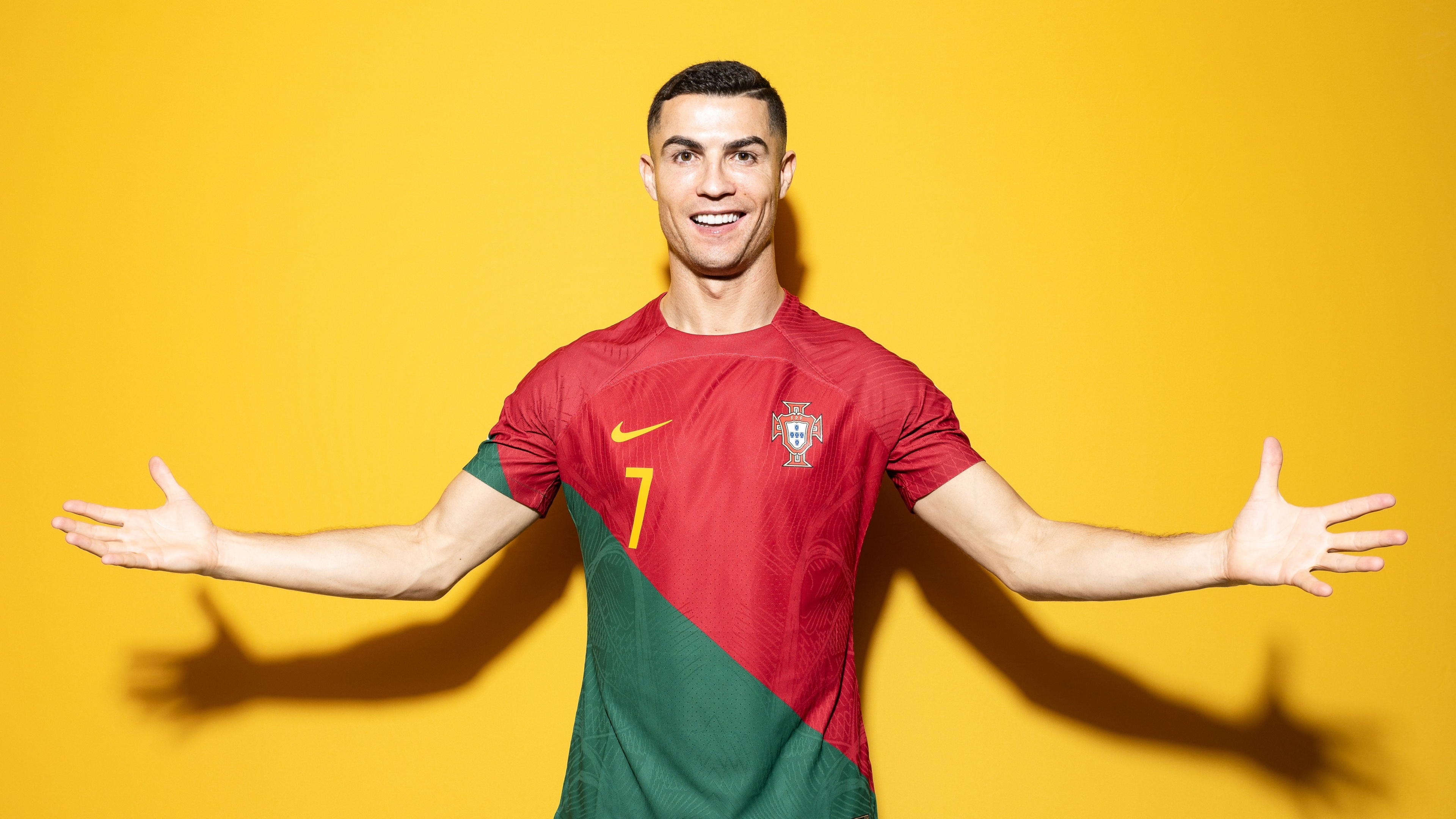 A professional portrait of Portuguese soccer star Cristiano Ronaldo against a bright yellow background.