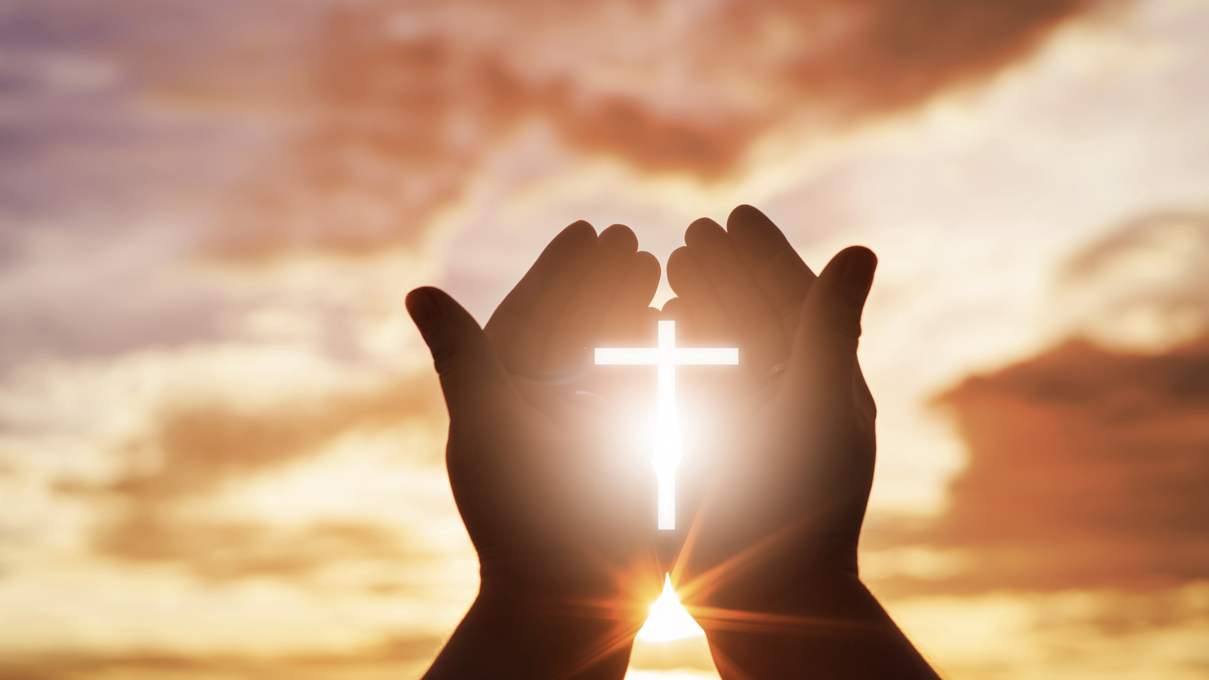 A Christian cross illuminated by bright, warm sunlight, symbolizing divine faith and spirituality.