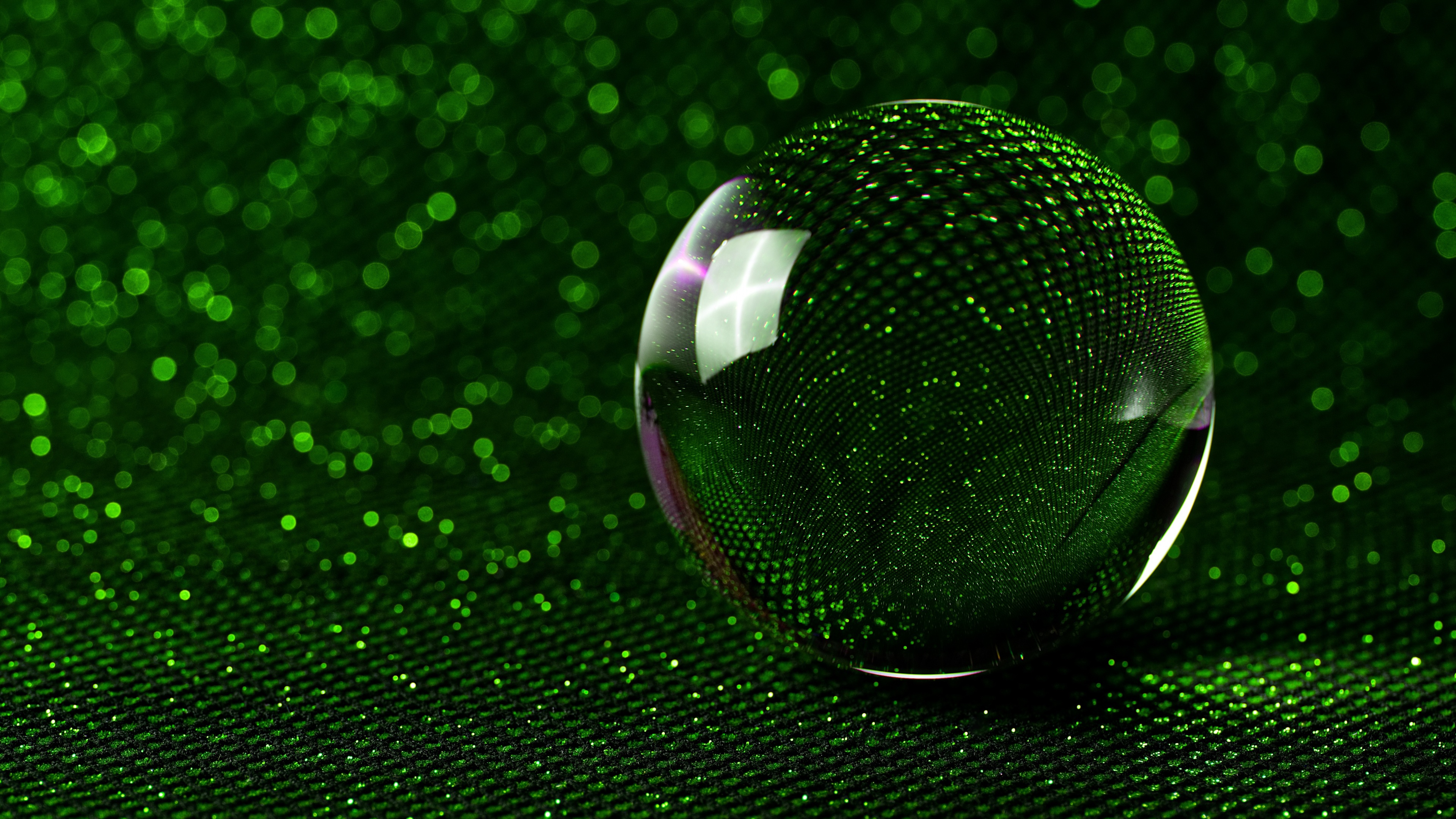 Macro shot of a glowing crystal ball with a green aesthetic and soft bokeh lights in the background