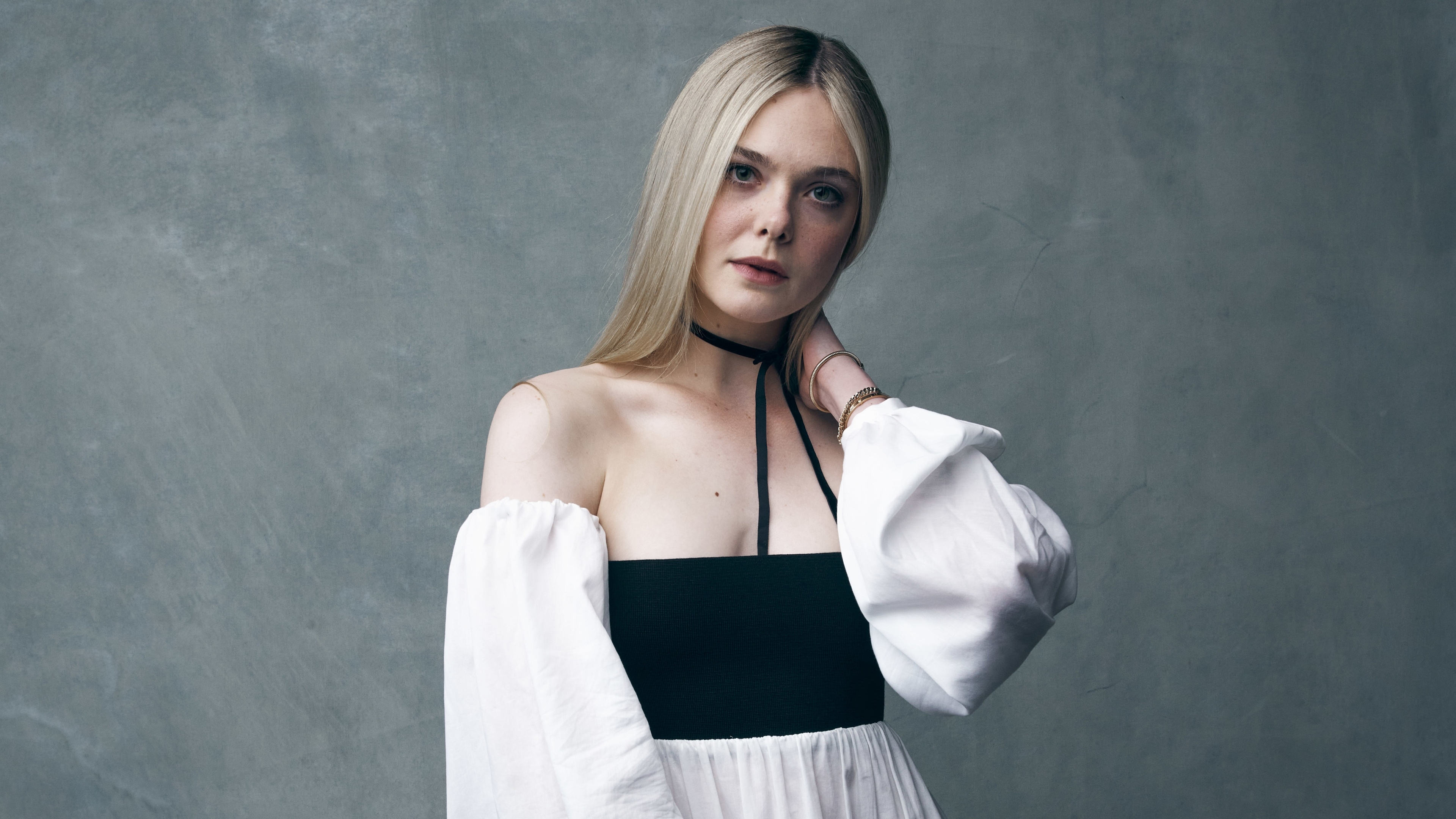 Close-up portrait of blonde actress Elle Fanning looking towards the camera.