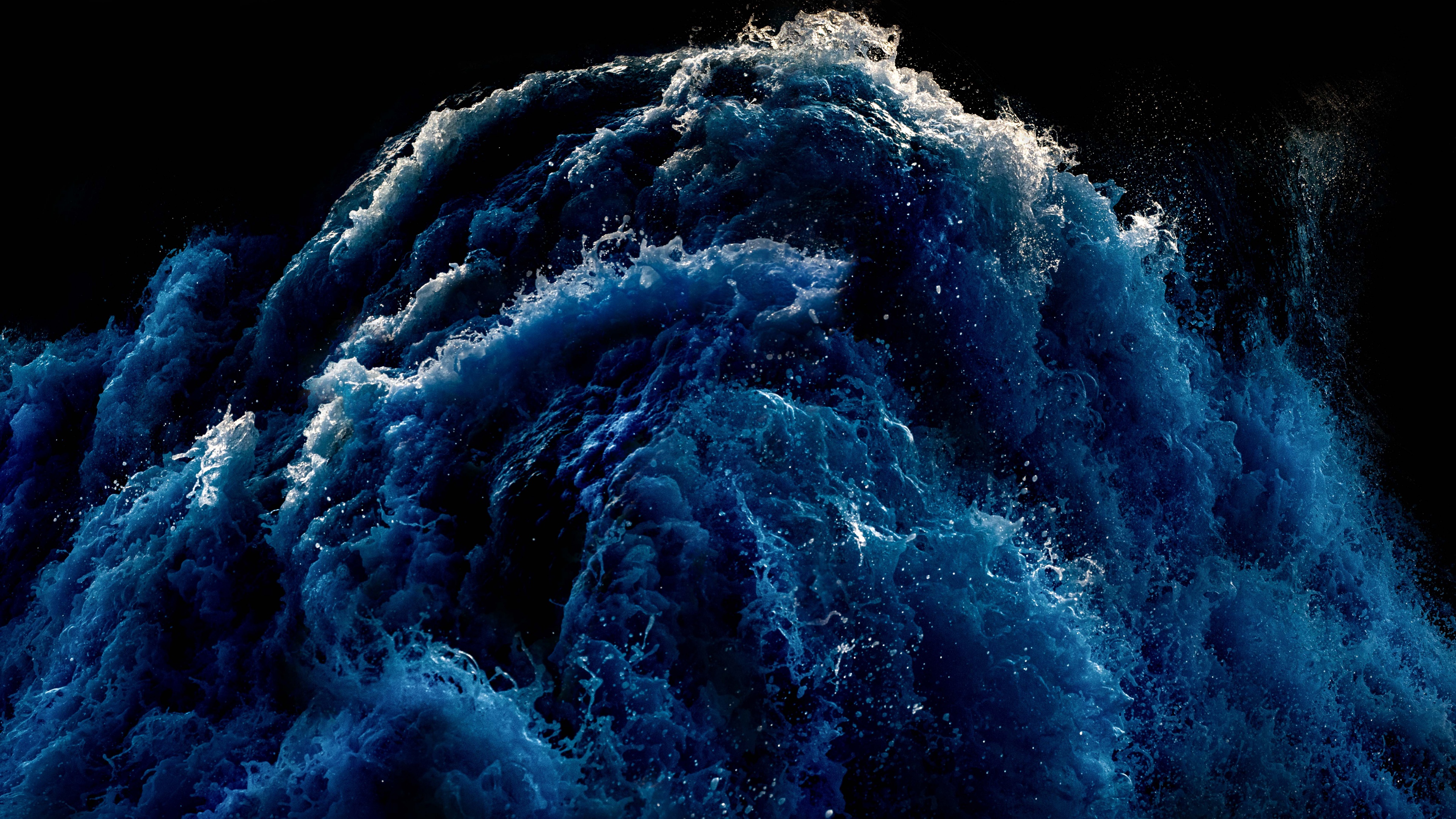 Dramatic deep blue ocean waves crashing during a coastal storm with intense sea spray.
