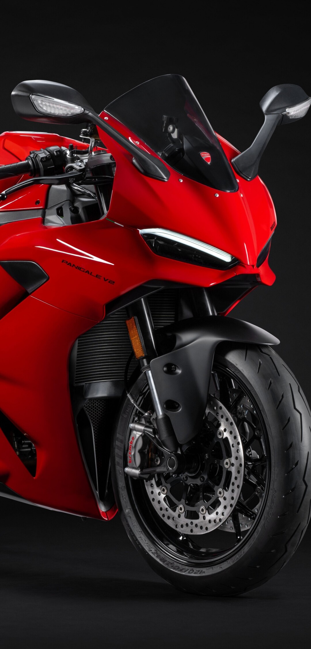 A high-detail, close-up view of a 2025 Ducati Panigale V2 sports motorcycle against a dark, atmospheric background.
