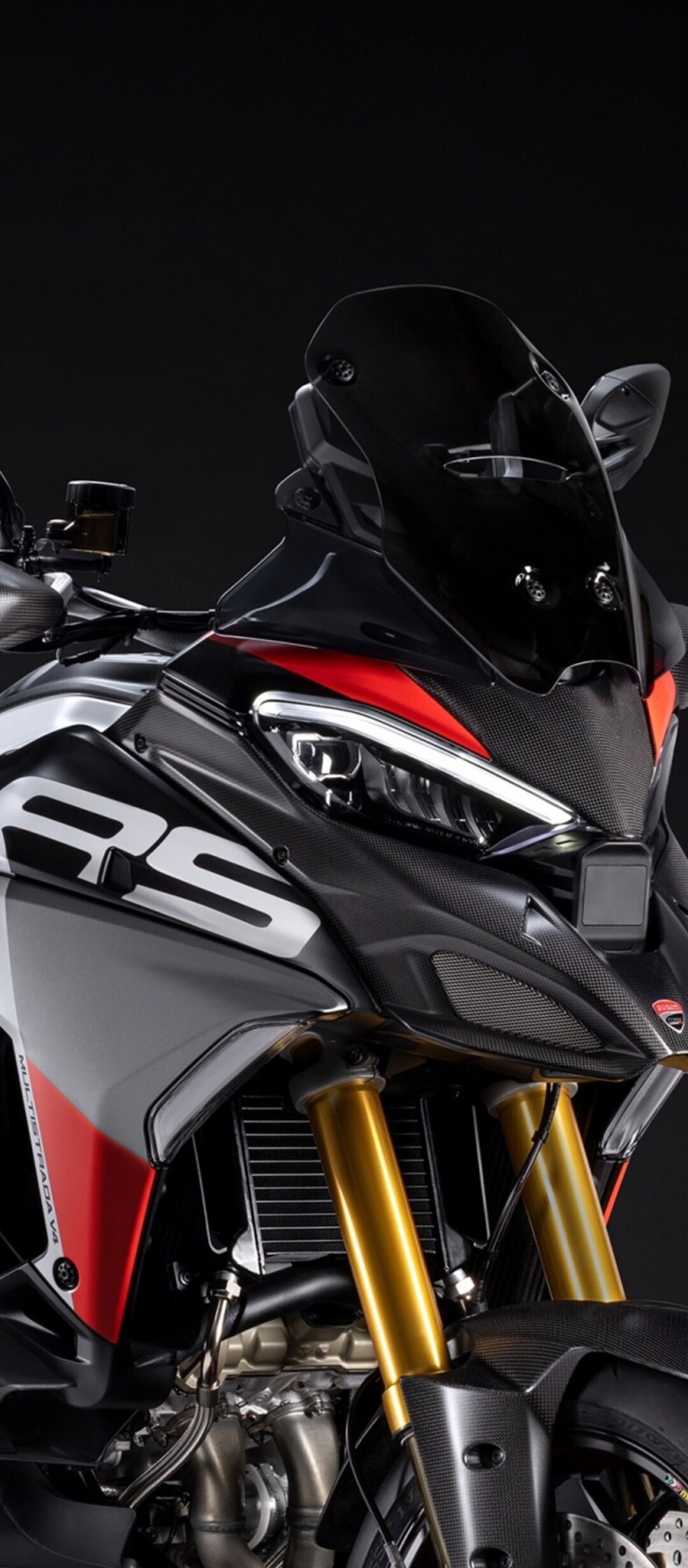 A close-up, high-detail shot of the 2026 Ducati Multistrada V4 RS adventure motorcycle in a dark studio environment.