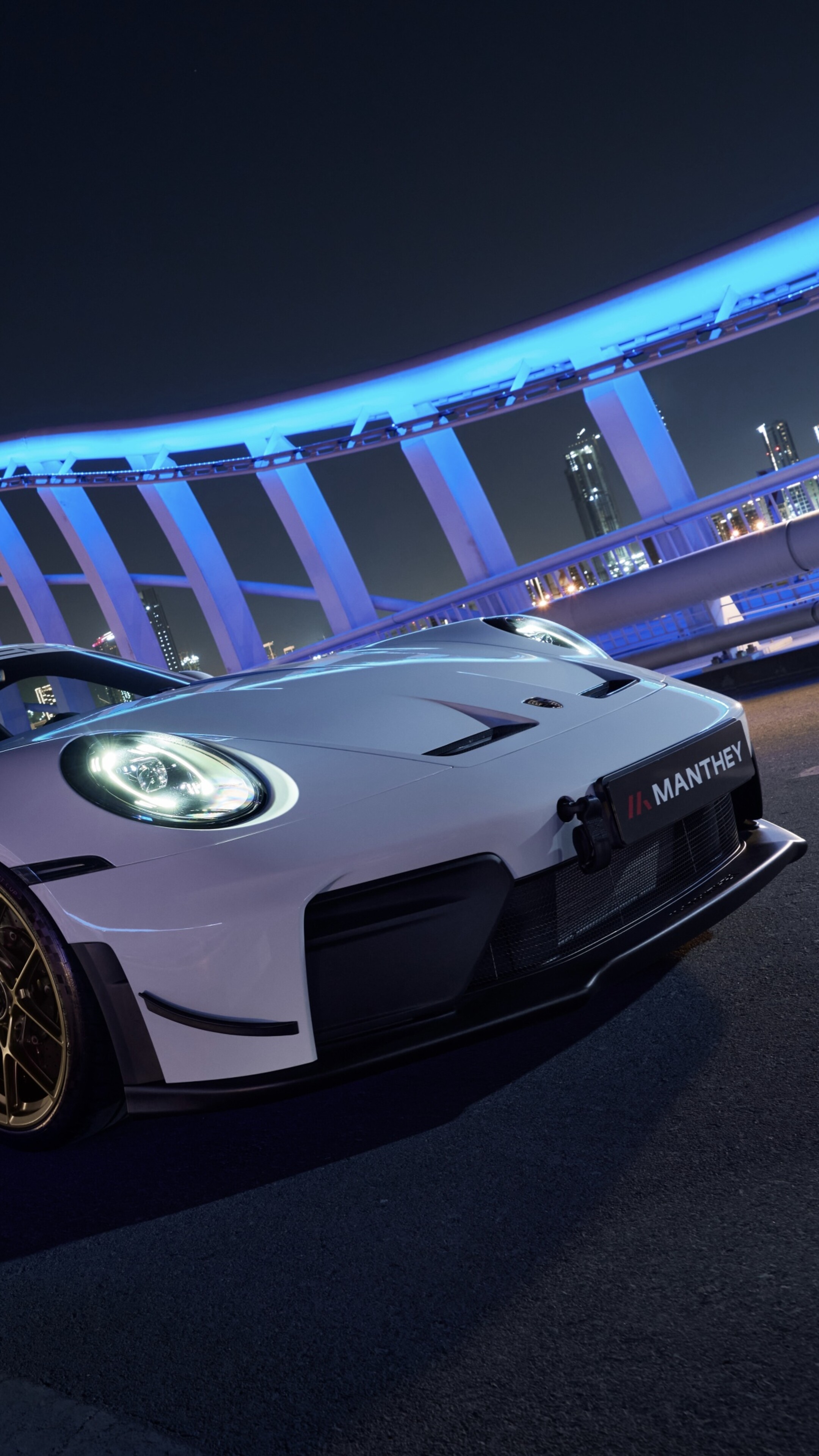 A high-detail, ultra-realistic view of a 2026 Porsche 911 GT3 equipped with a Manthey Performance Kit, showcasing its aerodynamic racing design.