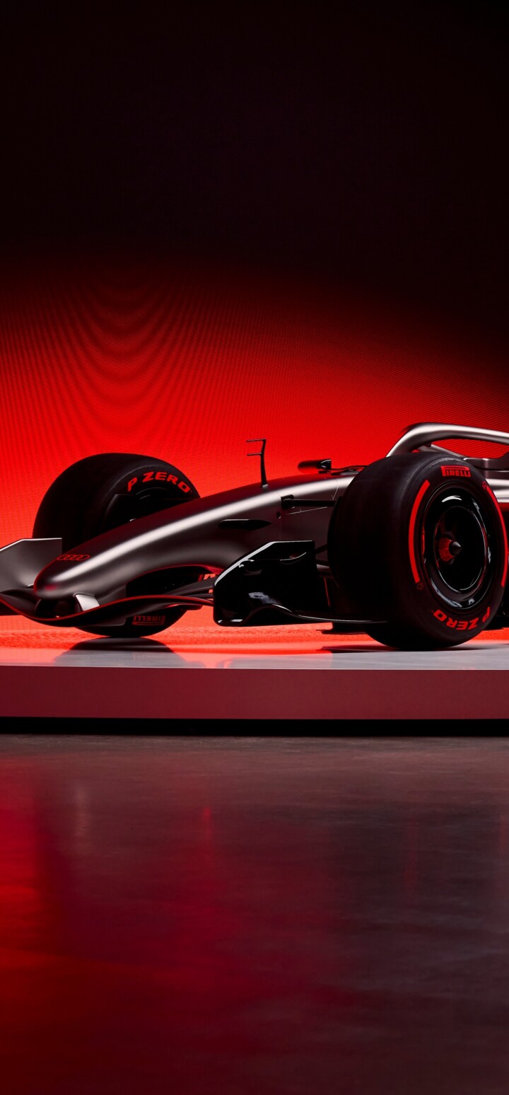 A sleek, dark red Audi R26 Concept Formula One racing car with an advanced aerodynamic body.