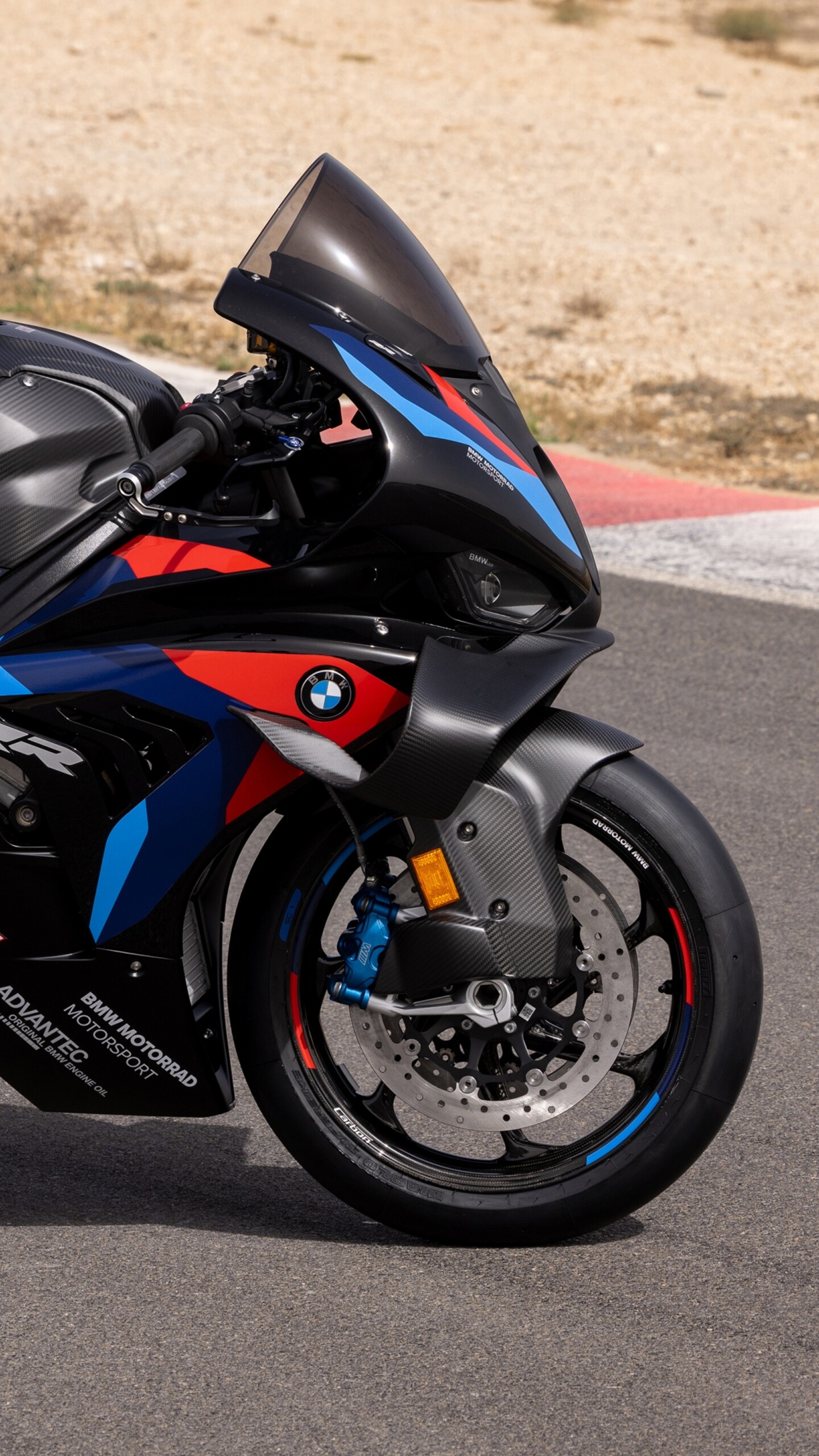 A BMW M 1000 RR sportbike parked on a clean asphalt road.