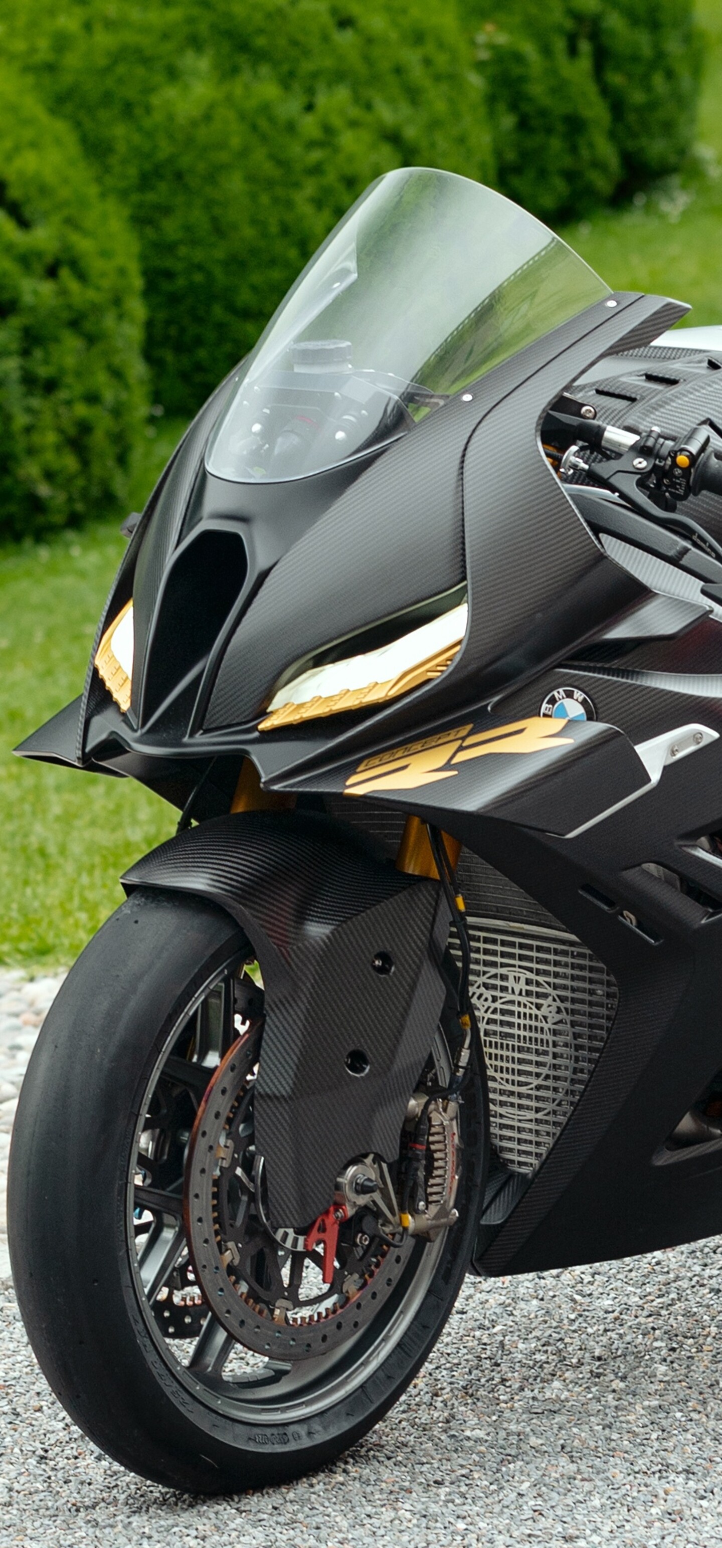 A futuristic BMW Motorrad Concept RR sports motorcycle with sleek aerodynamic fairings and advanced LED lighting, set against an outdoor backdrop.