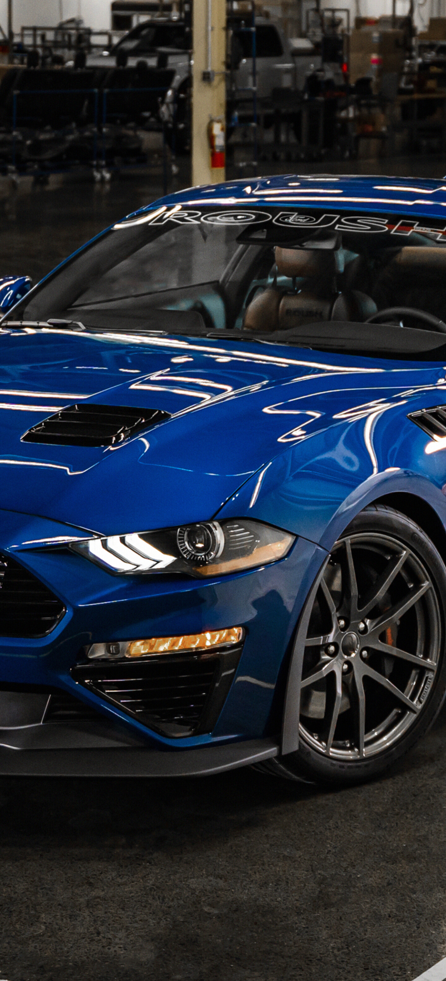 A high-performance blue Ford Mustang muscle car parked outdoors.