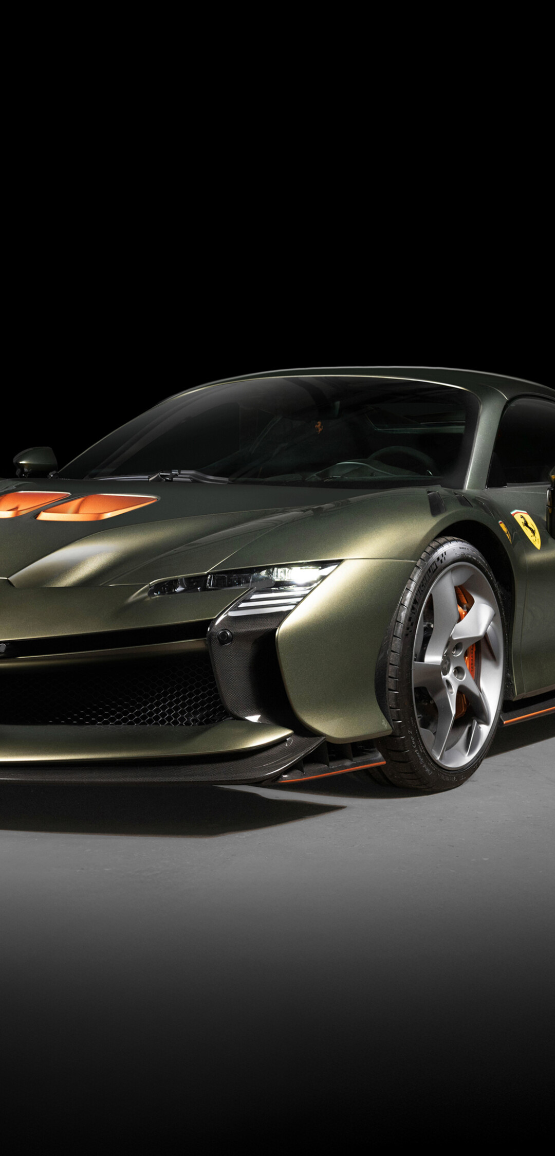 A high-performance Ferrari SF90 XX Spider supercar captured in a dark, atmospheric setting highlighting its sleek design.