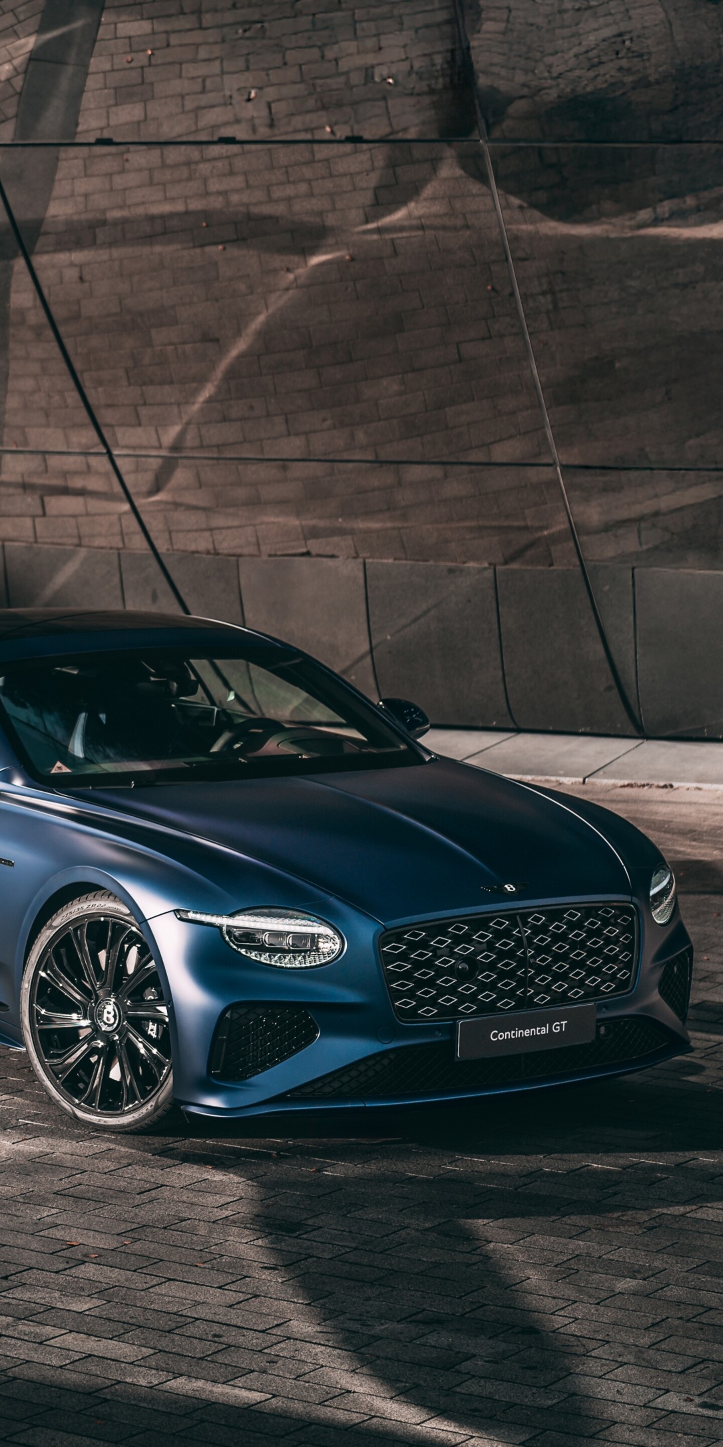 A futuristic Bentley Continental GT with advanced aerodynamic features and glowing lights in a high-resolution setting.