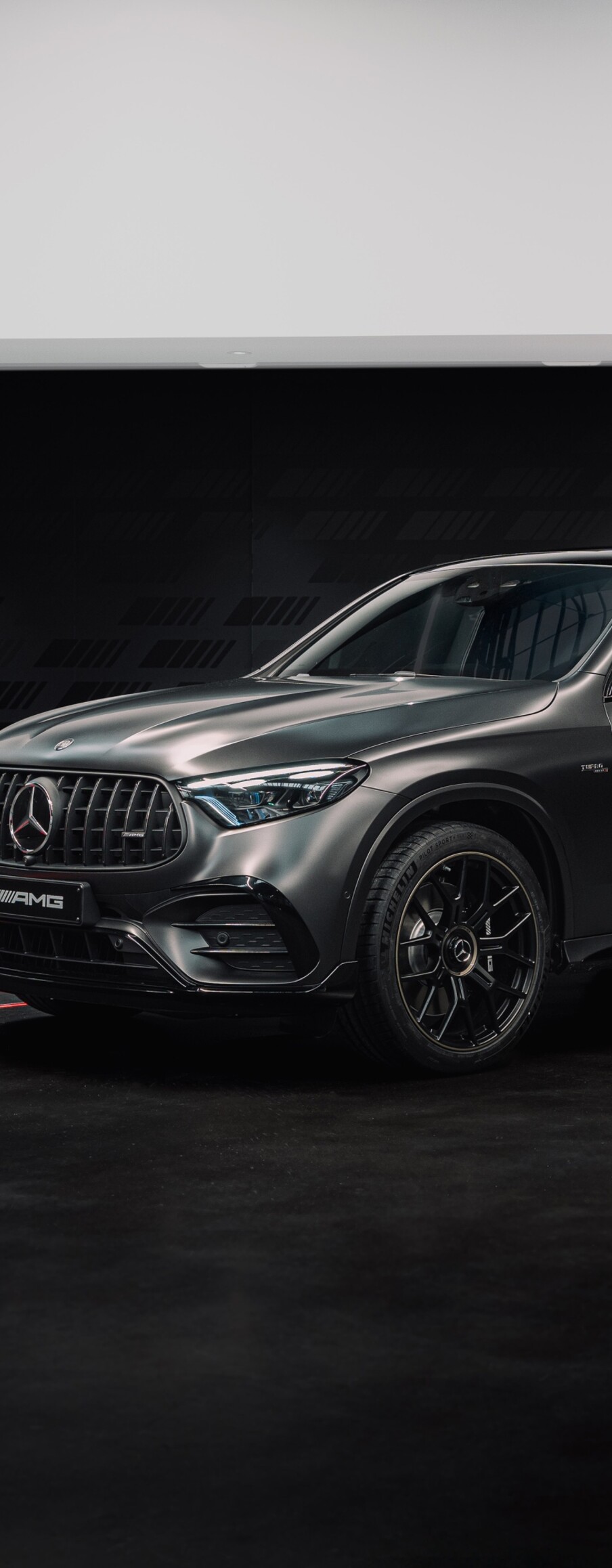 A high-resolution, cinematic shot of a Mercedes-AMG luxury sports car in a dark, atmospheric setting.