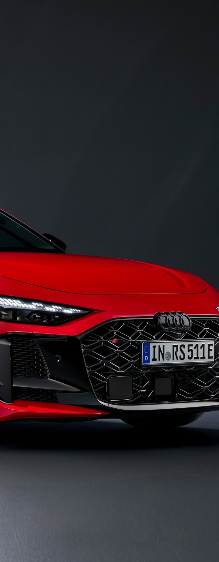 A collection of aerodynamic, bright red luxury cars driving through a modern urban landscape in the year 2026.