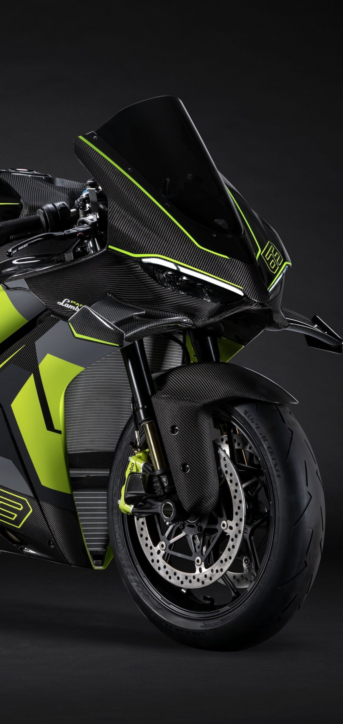 A Ducati Panigale V4 motorcycle and a Lamborghini supercar showcased together against a dramatic dark background.