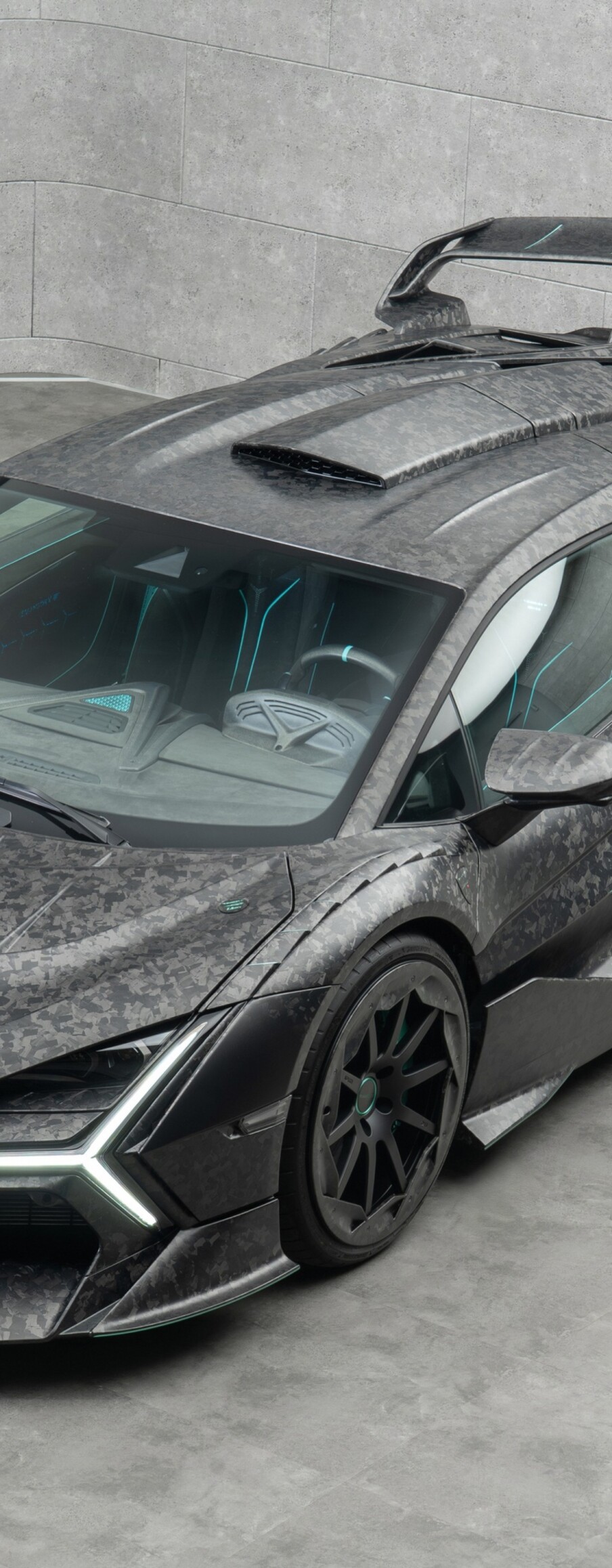 A detailed view of a Lamborghini Revuelto featuring exposed carbon fiber elements and sleek automotive design.