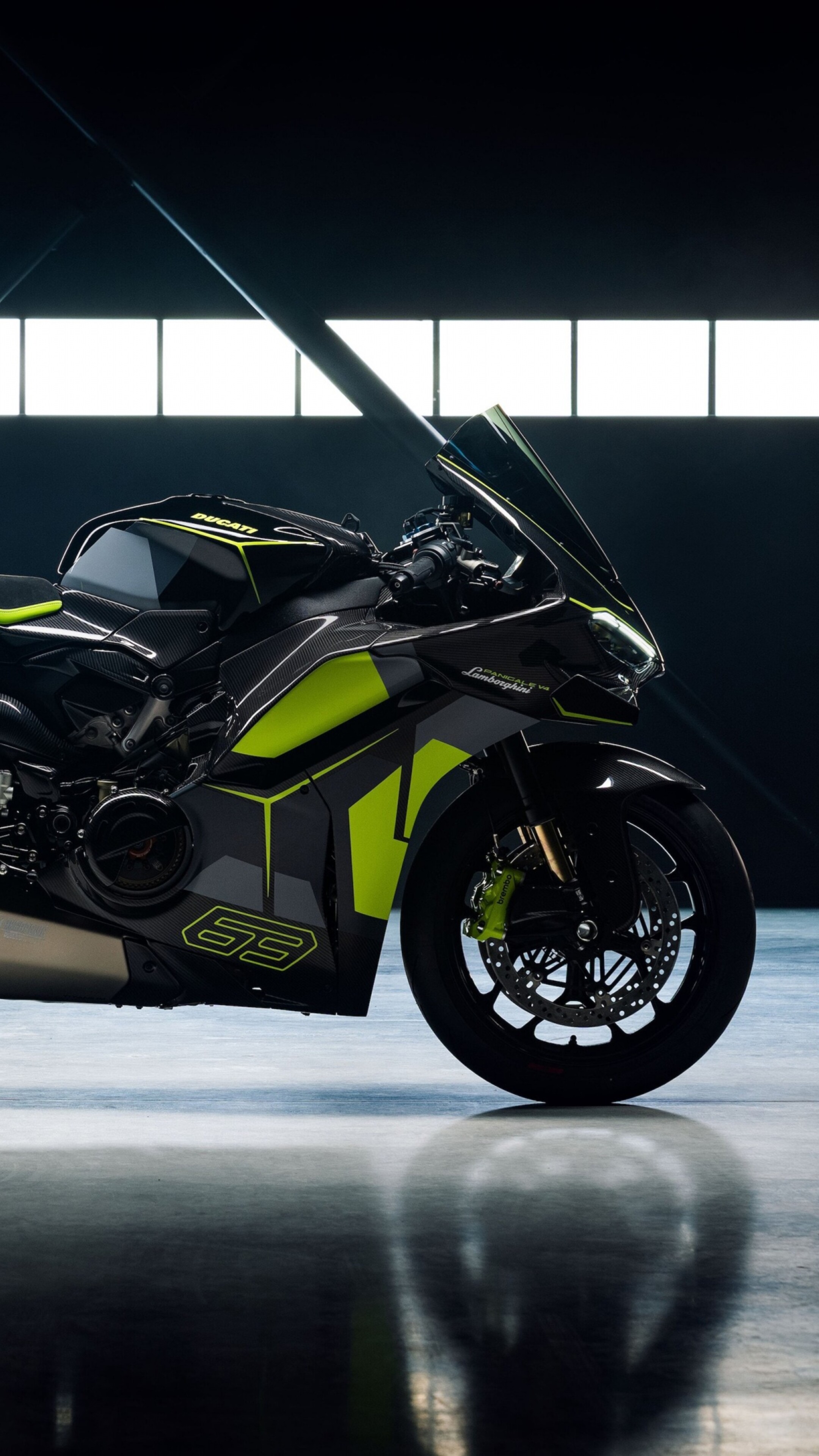 A neon green Ducati Panigale V4 motorcycle and a Lamborghini parked in a luxury garage.
