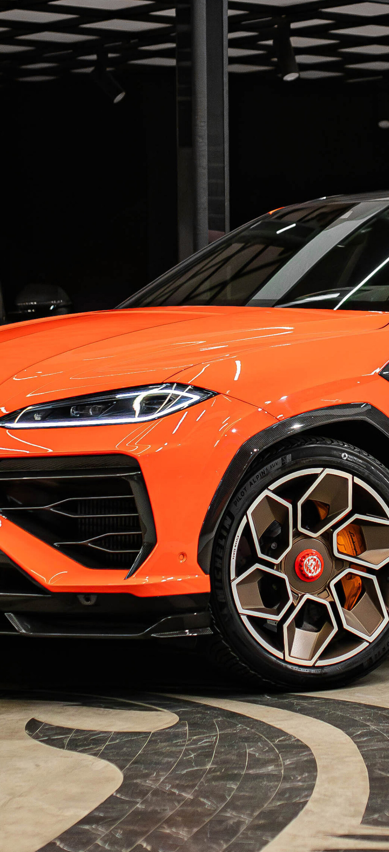 A vibrant orange Lamborghini Urus SE featuring a custom widebody kit by TopCar Design.