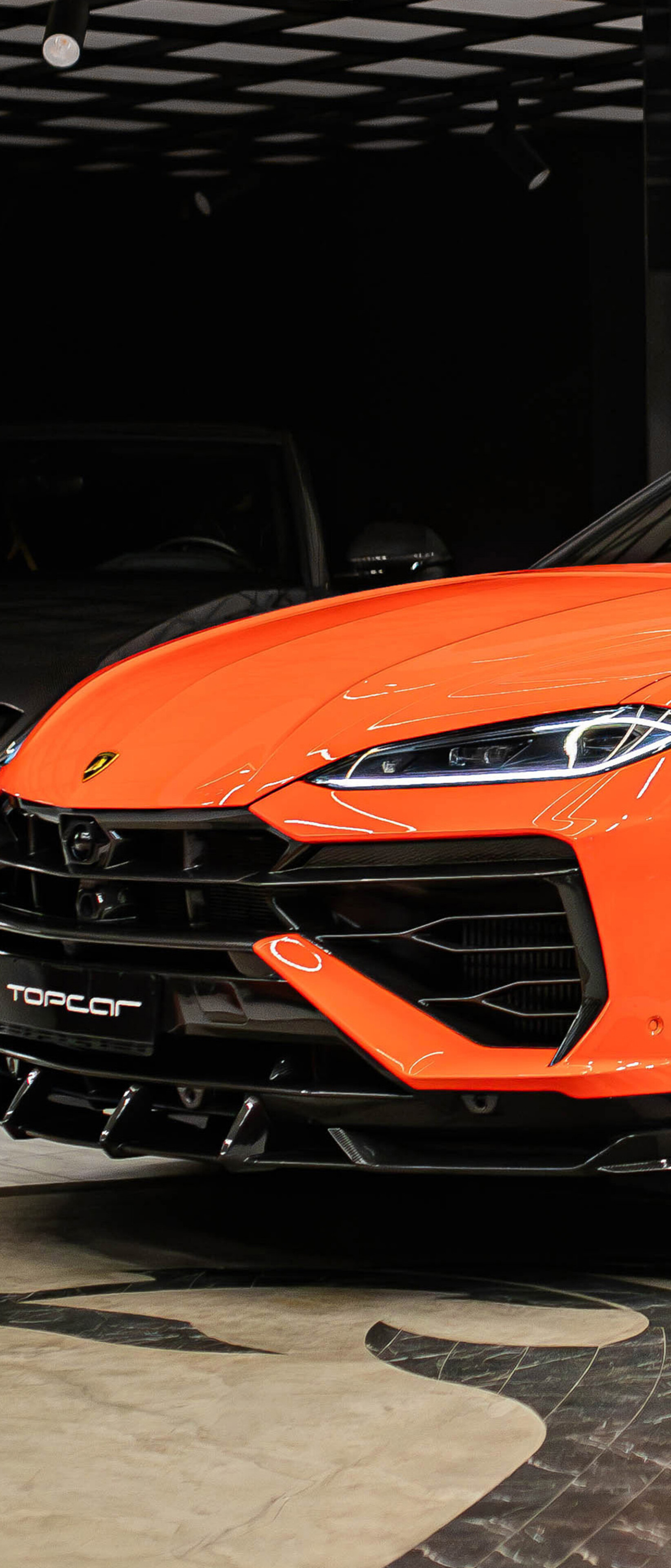 A vibrant orange Lamborghini Urus SE featuring custom TopCar Design widebody modifications and aggressive styling.
