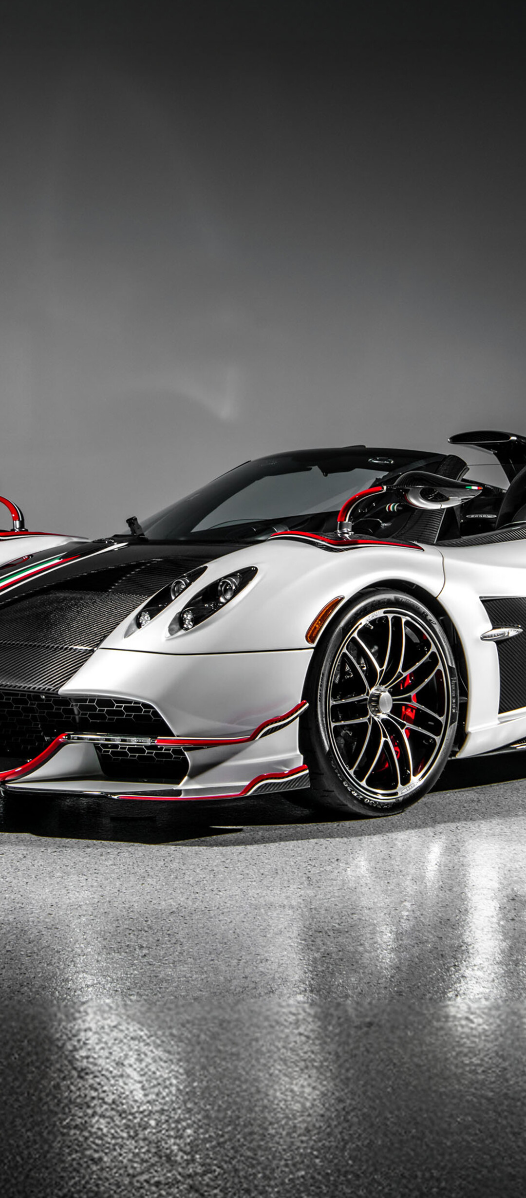 A Pagani Huayra Roadster hypercar featured against a dark, minimalist background with dramatic lighting.