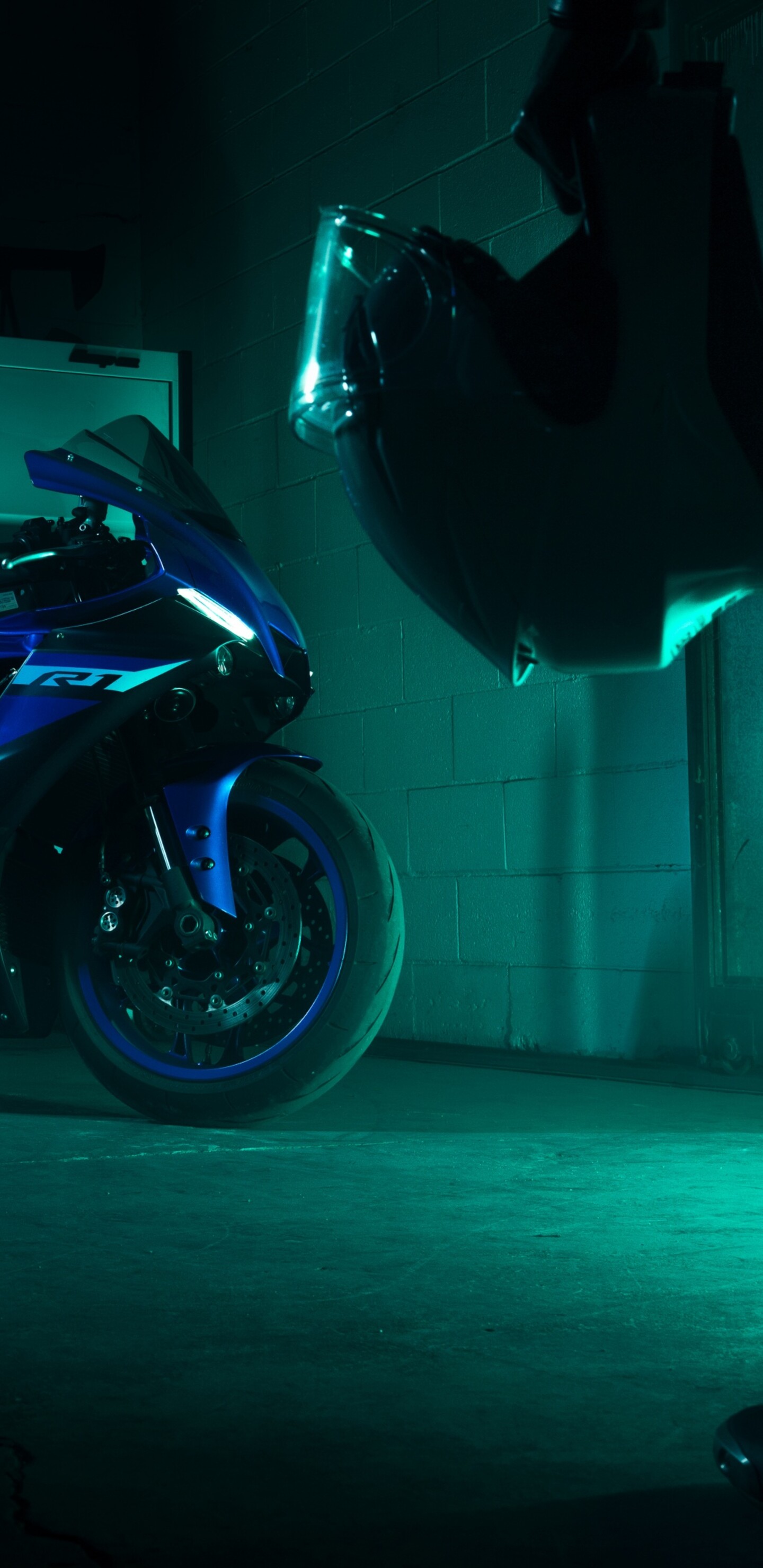 A biker in protective gear sitting on a sleek Yamaha YZF-R1 sport motorcycle.