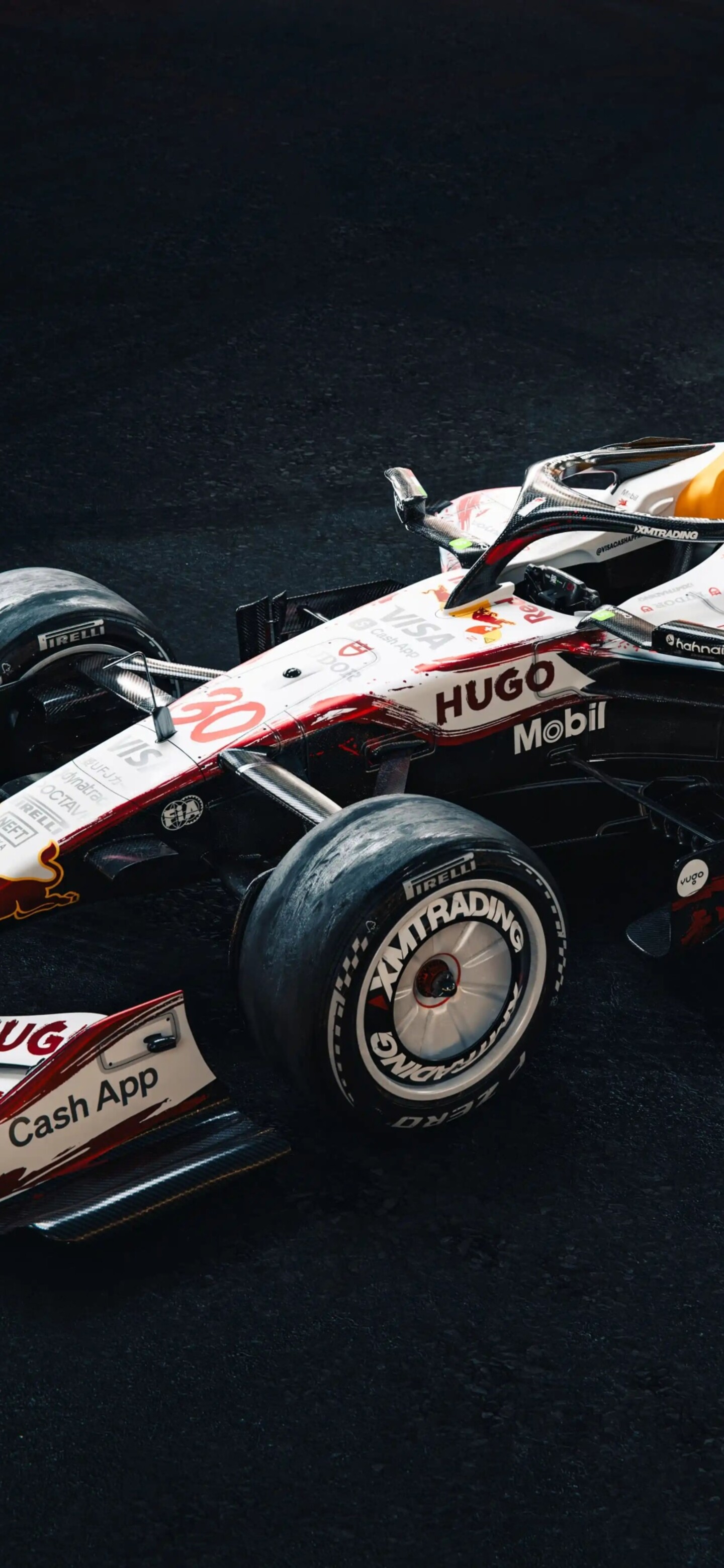 A detailed view of the VCARB 03 Racing Bulls Formula One car under dark, cinematic lighting at the Japanese Grand Prix.
