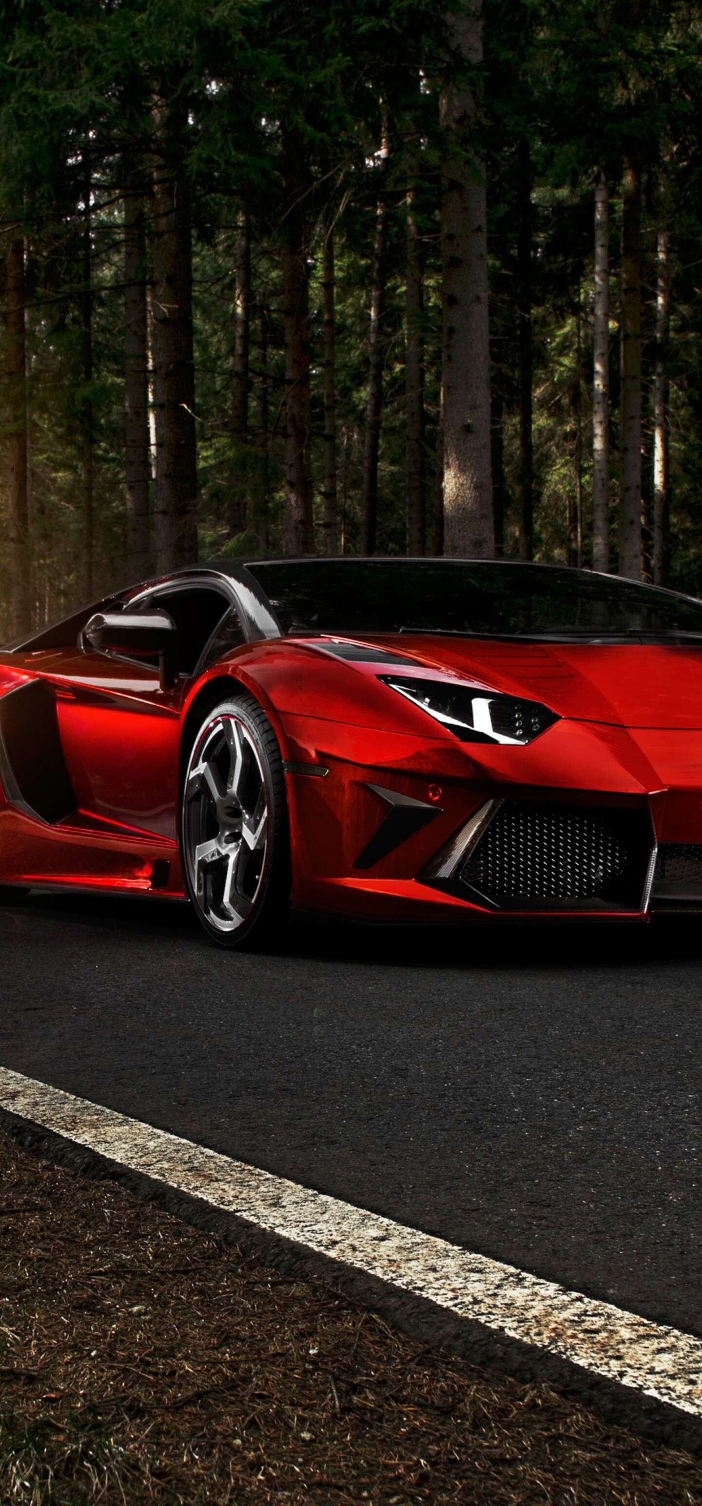 A sleek red Lamborghini Aventador LP 700-4 parked on an asphalt road under bright sunlight.