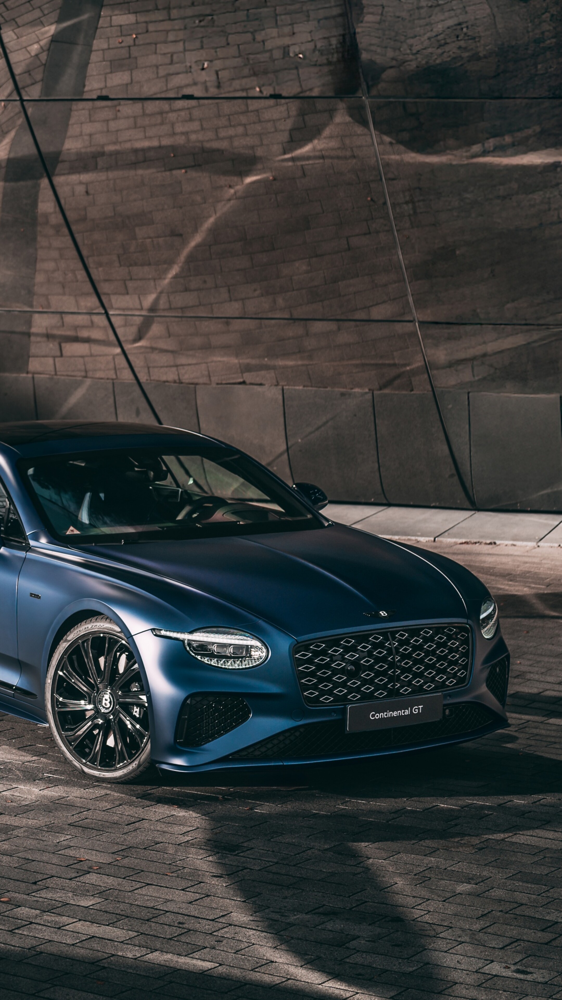 A futuristic Bentley Continental GT with advanced aerodynamic features and glowing lights in a high-resolution setting.
